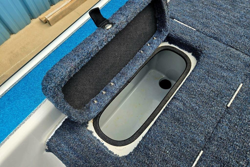 1996 Champion 181 SX boat storage compartment with blue carpeted interior.