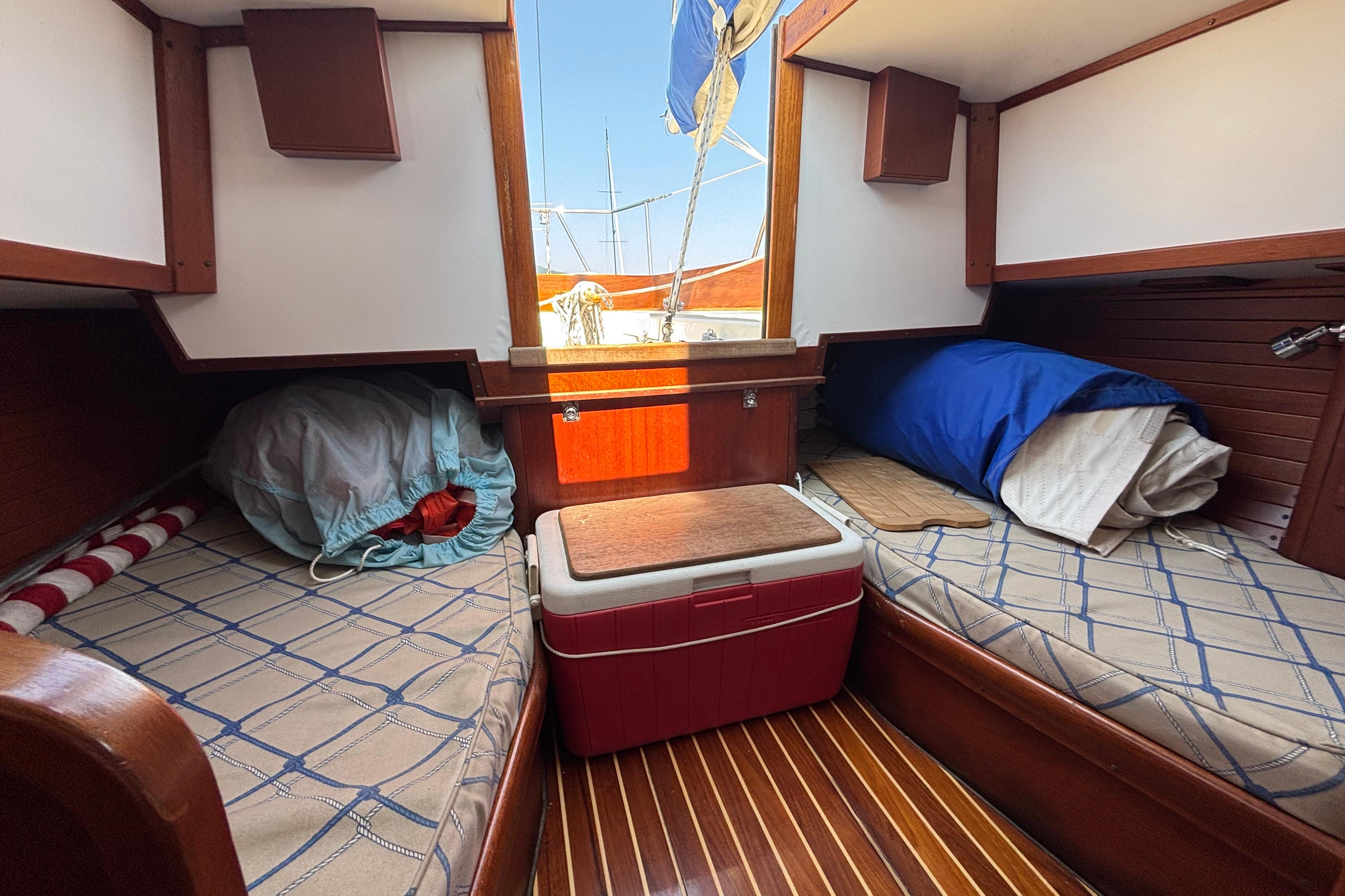 Interior of 1998 Hank Hinckley Great Harbor 26 boat with twin beds and wooden accents.
