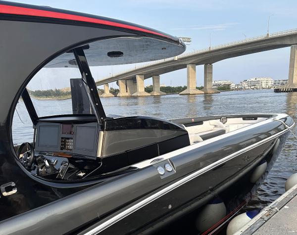 2017 Mystic Powerboats M4200 docked near a bridge on a sunny day.