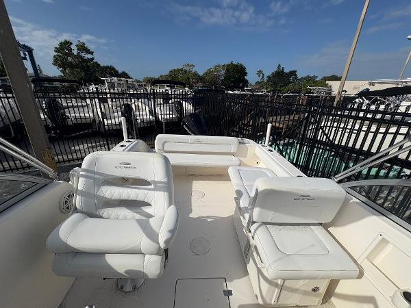 2020 Cobia 220 Dual Console boat interior with white seating, docked under clear skies.