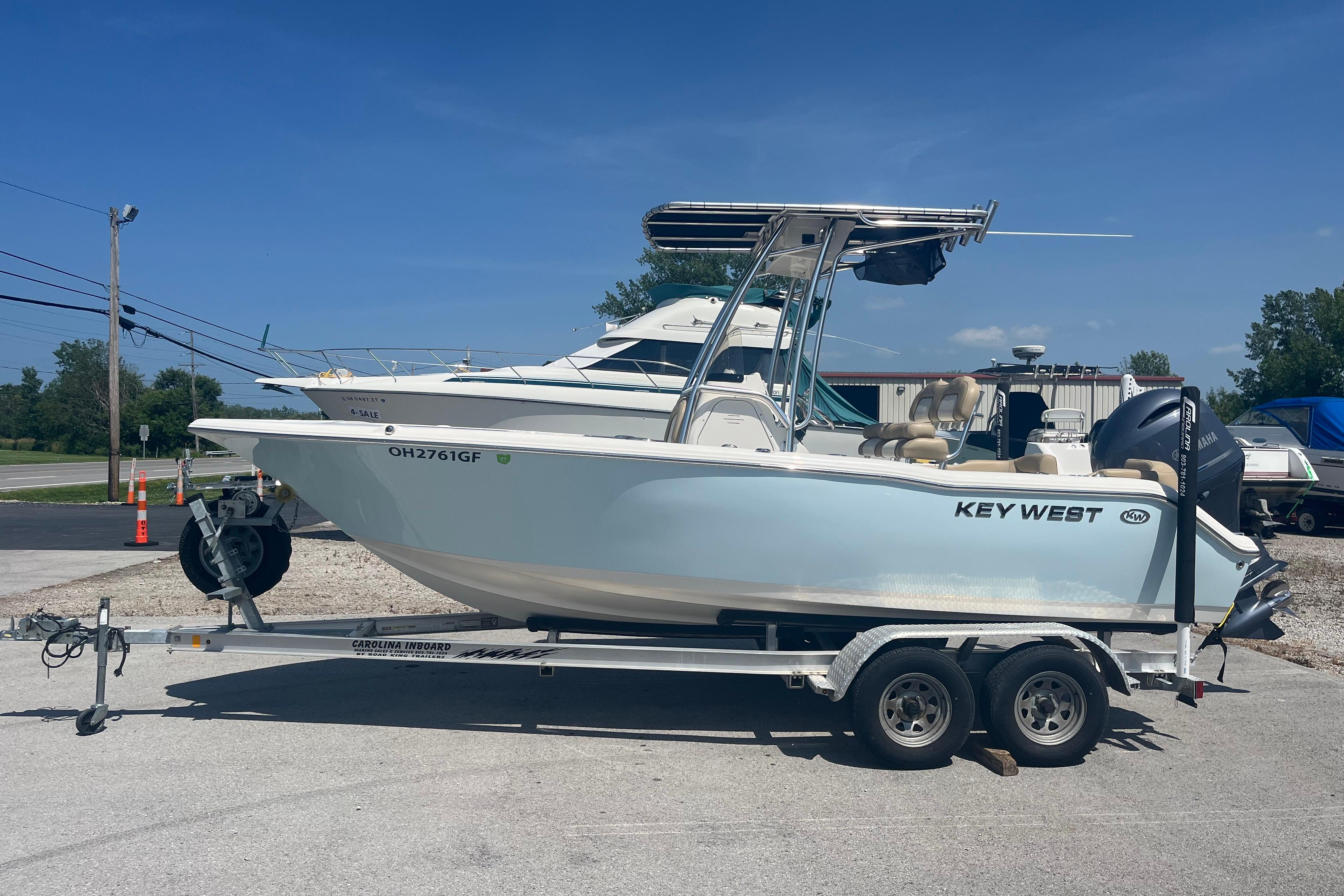 2017 Key West 203 FS boat on trailer, parked outdoors under clear blue sky.