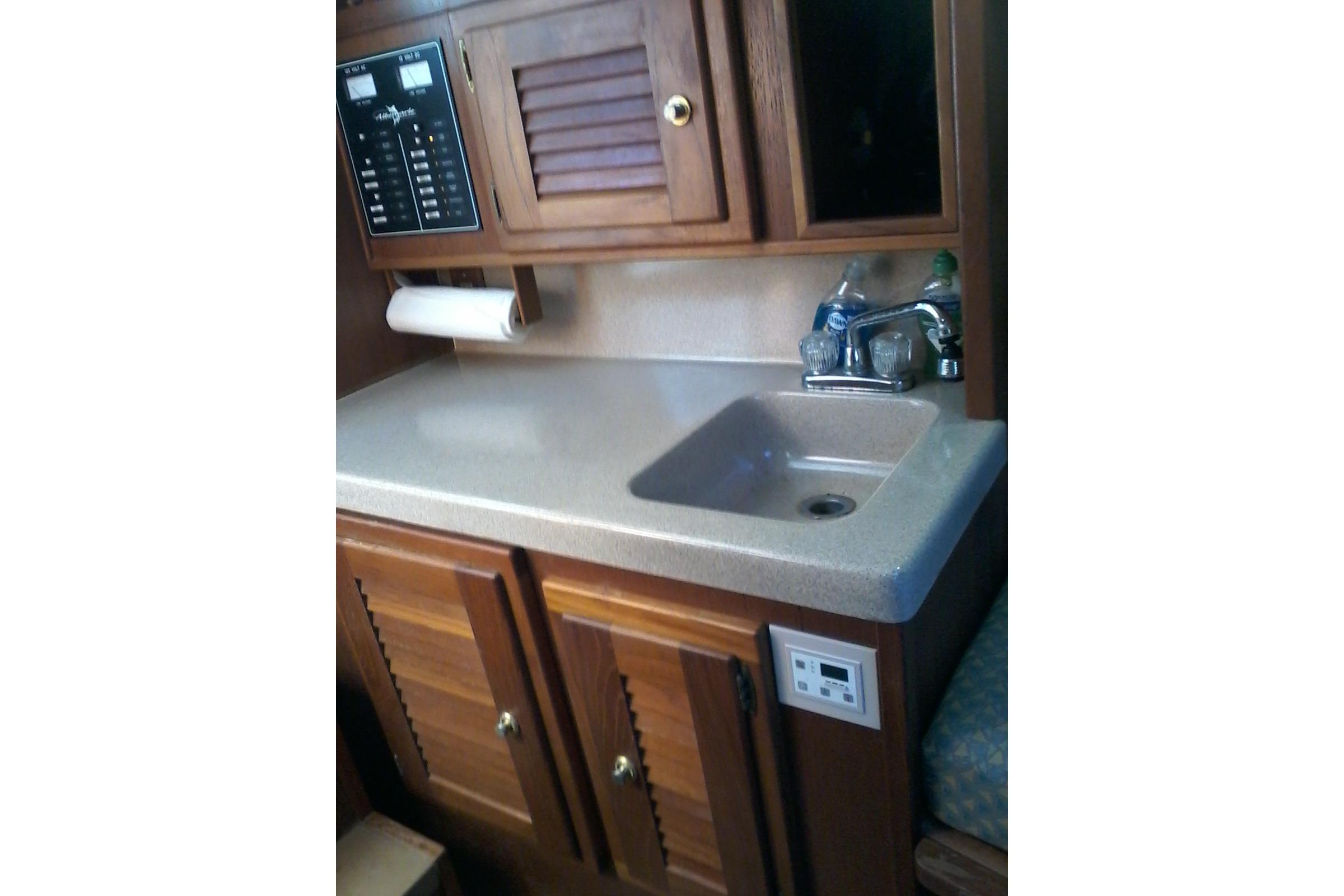 2002 Albemarle 265 Express Fisherman boat interior with sink and wooden cabinetry.