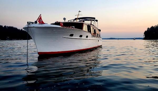 1951 Chris-Craft Catalina boat on calm water at sunset, showcasing classic design.