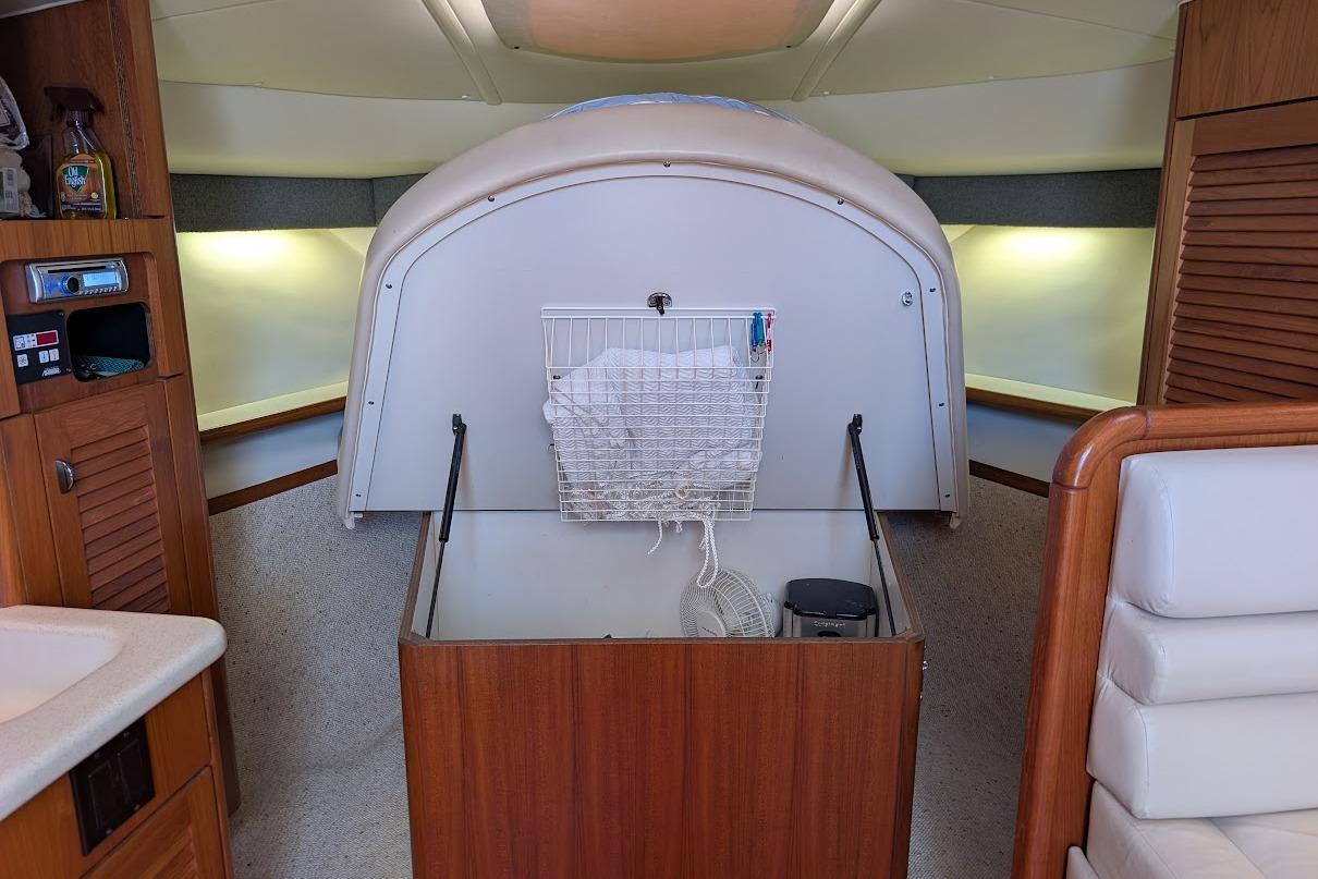Interior of a 2000 Pursuit 3400 Express boat with wooden cabinetry and storage area.