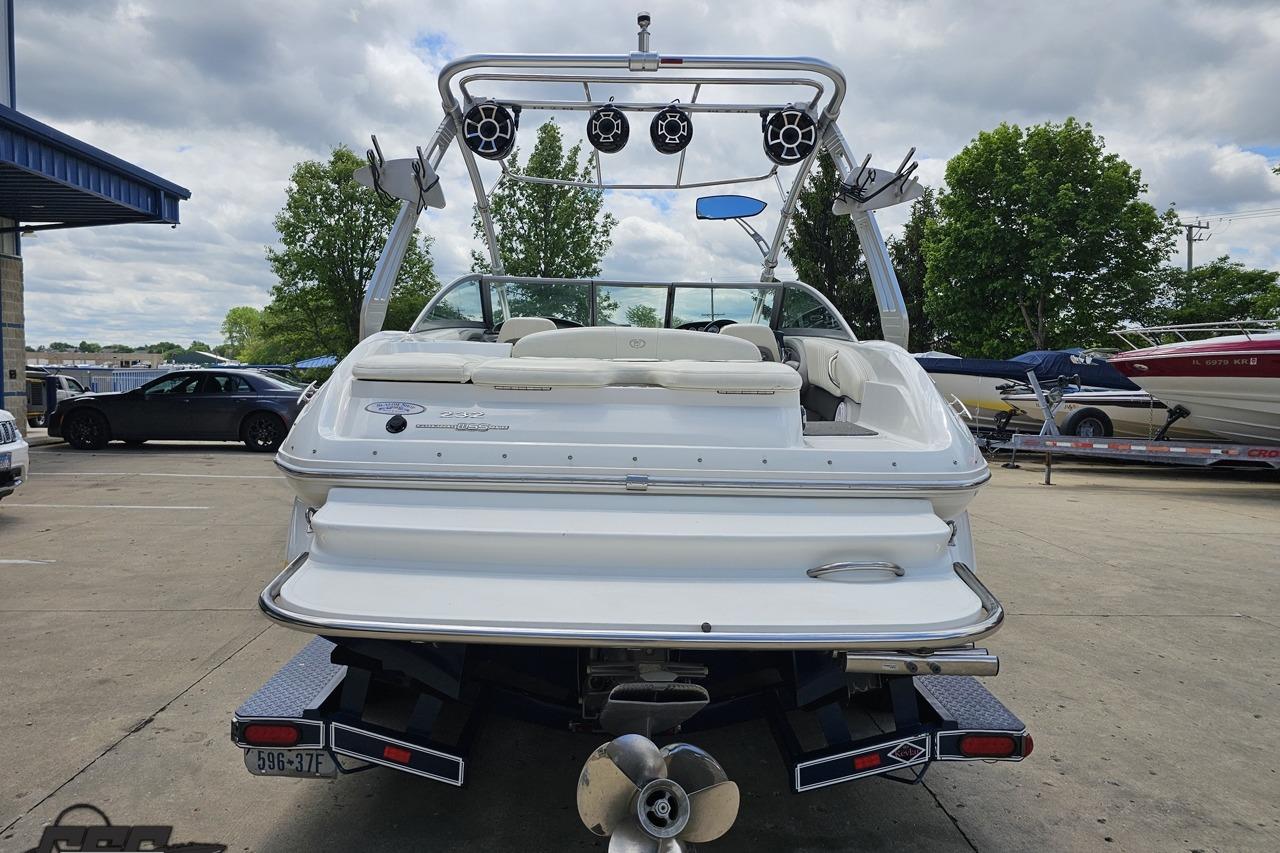 2010 Cobalt 232 WSS boat with wakeboard tower, parked outdoors on a cloudy day.