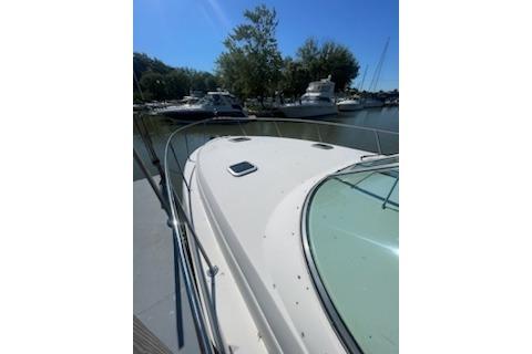 2000 Rinker Fiesta Vee 310 boat docked in a serene marina setting.
