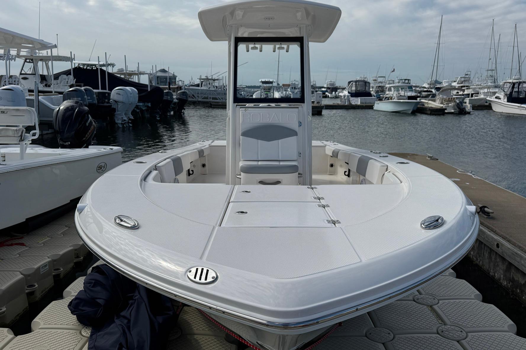 2021 Robalo 246 Cayman boat docked at a marina with other vessels.