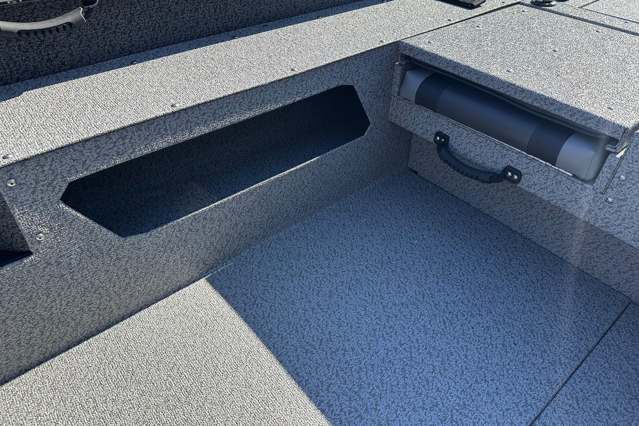 2026 Lund 1875 Impact XS SS boat interior with storage compartments and textured flooring.