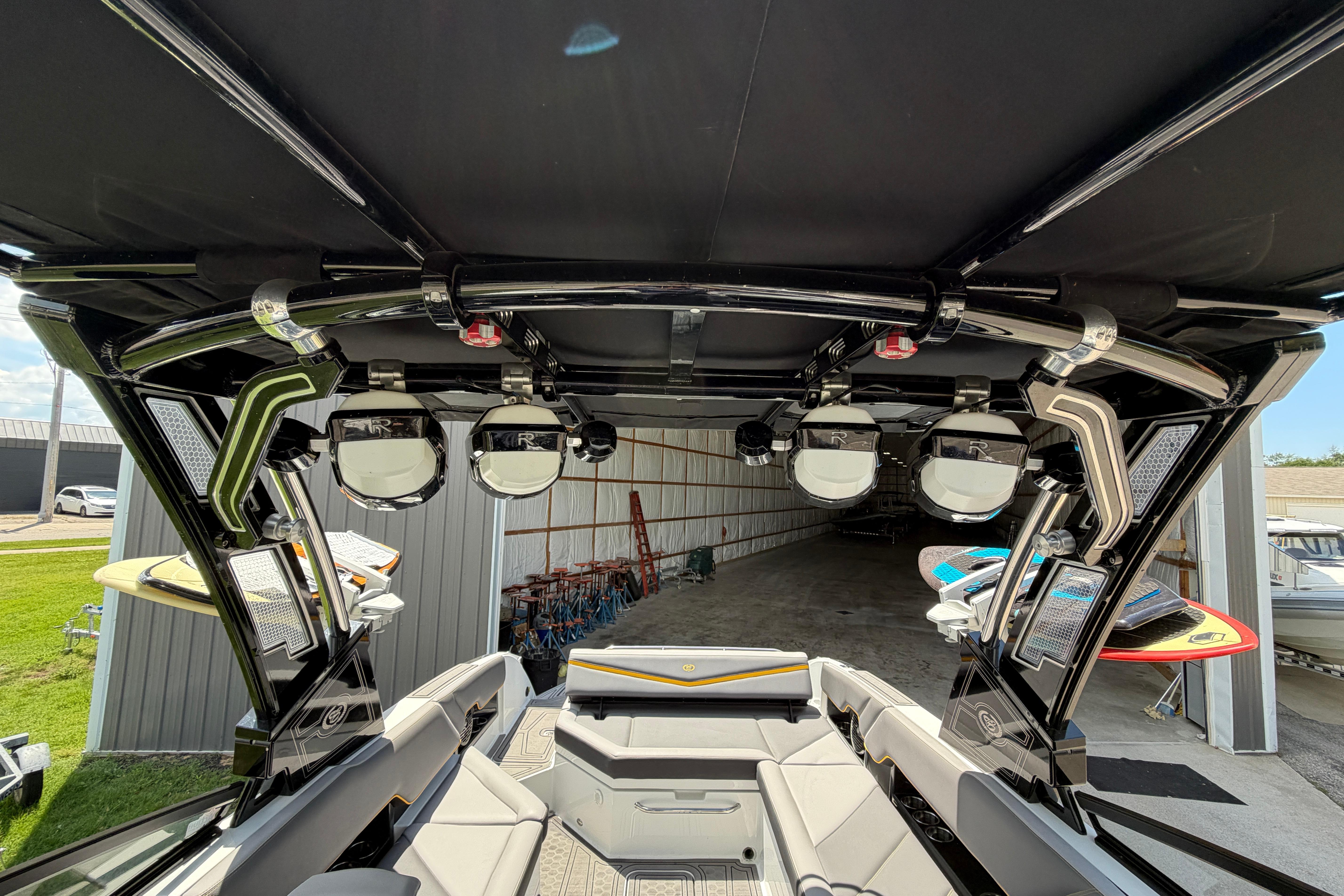 2021 Cobalt R8 Surf boat interior with speakers and surfboards in storage.