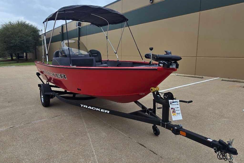 2026 Tracker Pro Guide V-16 SC boat in red on a trailer, parked outdoors.