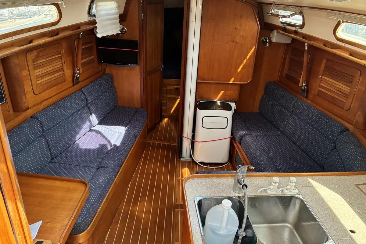 Interior of a 1998 Sabre 36 sailboat with wooden finish and blue seating.