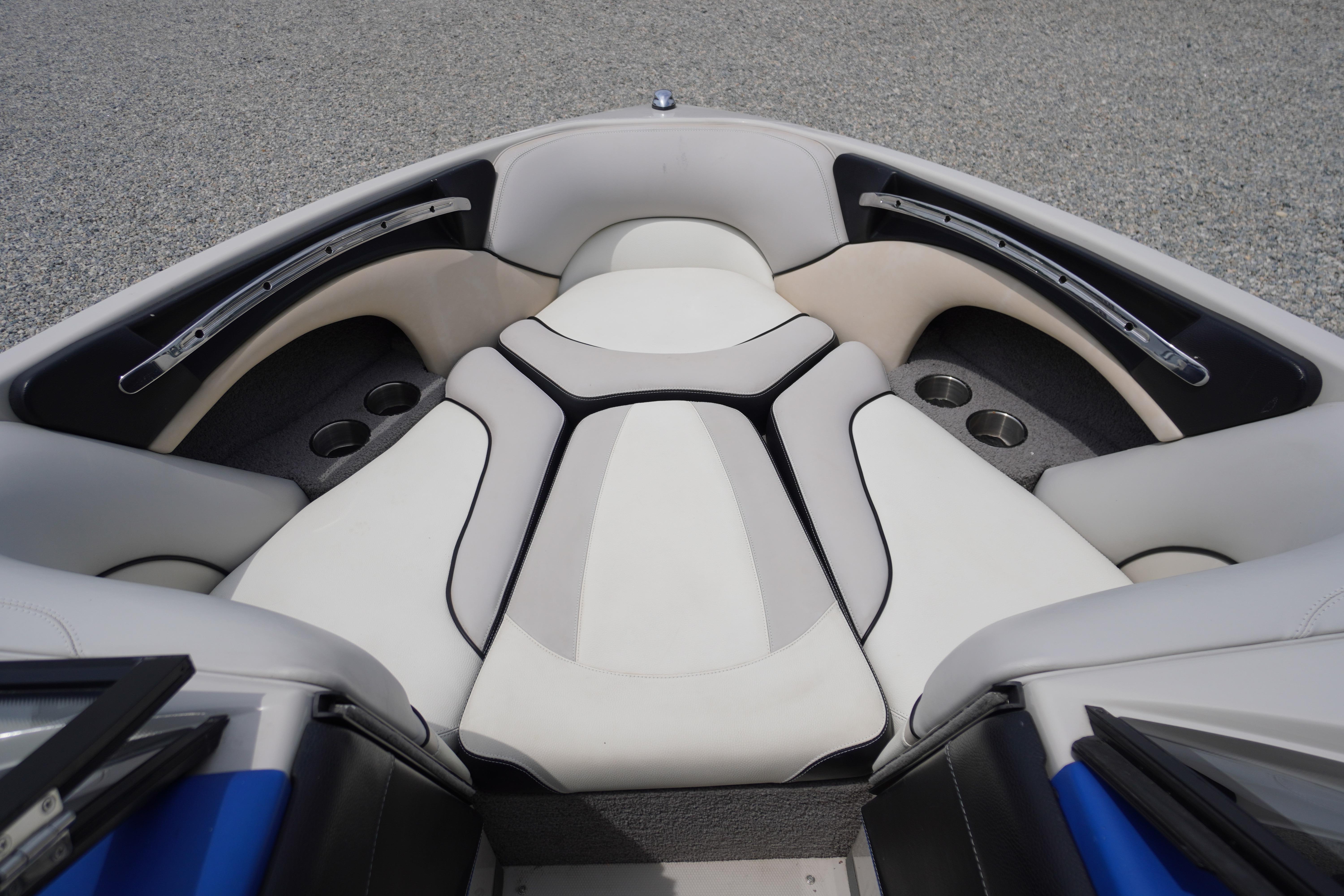 2011 Malibu Wakesetter 21 VLX boat interior with white cushioned seating and cup holders.