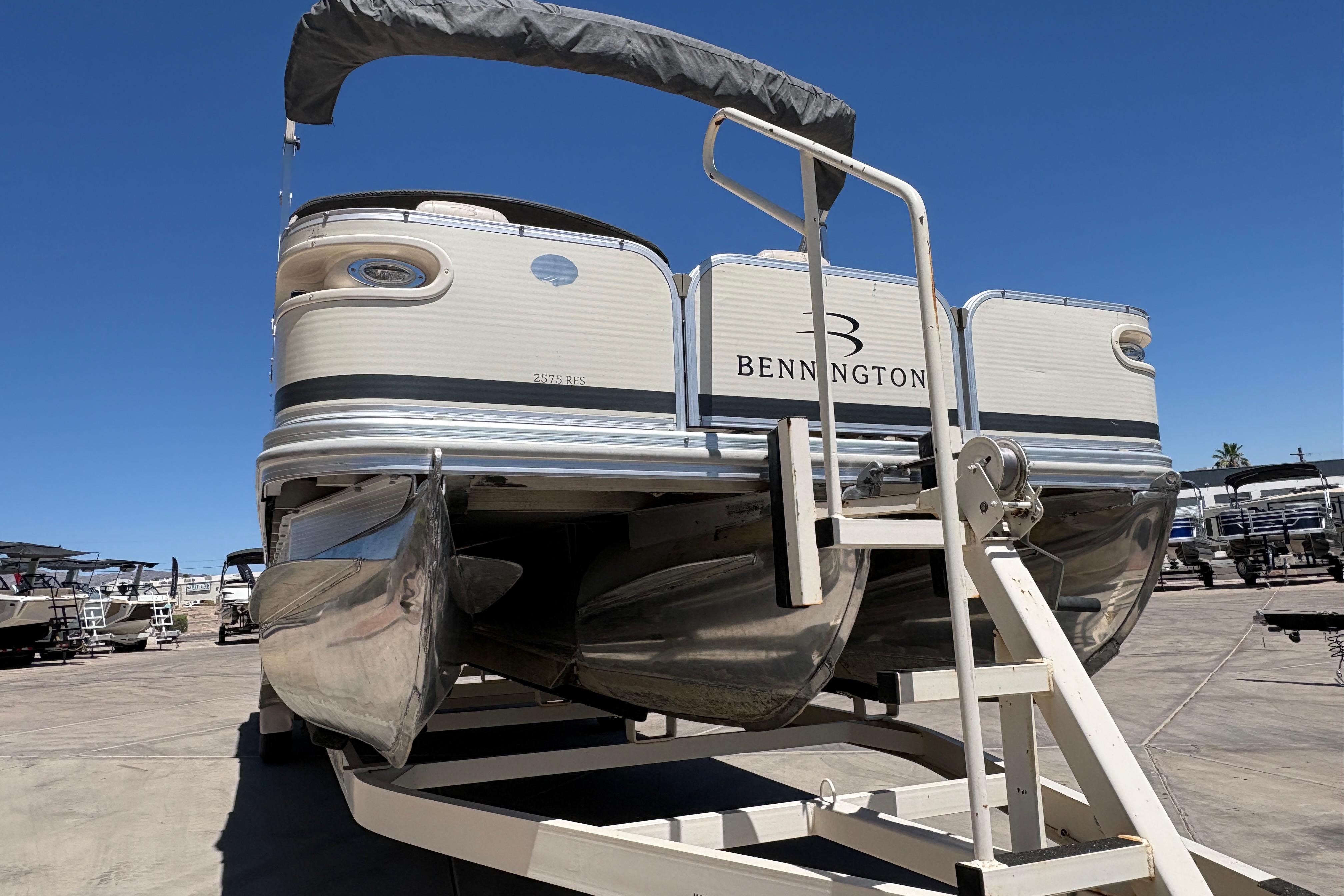 2005 Bennington 2575RFS I/O pontoon boat on trailer under clear blue sky.