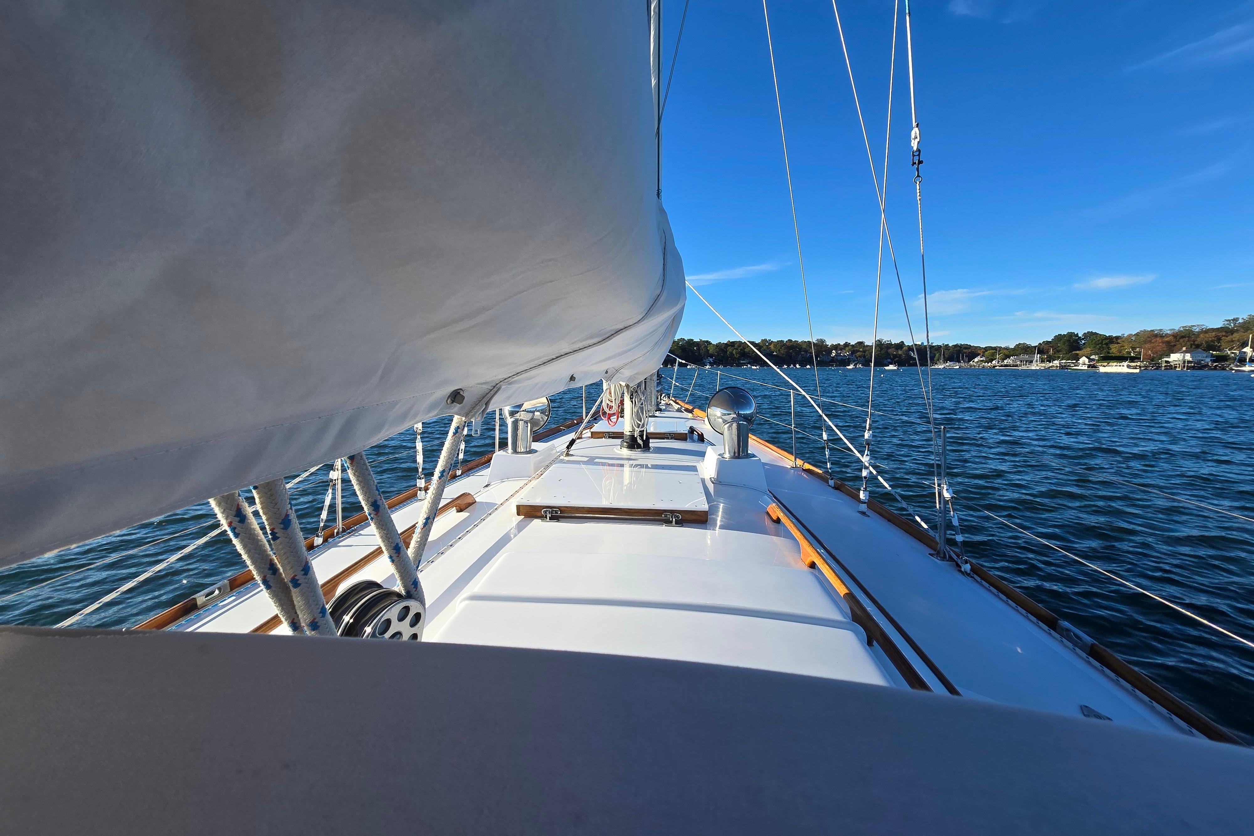 Sailing on a 1970 Hinckley Bermuda 40 yacht, blue skies and calm waters.