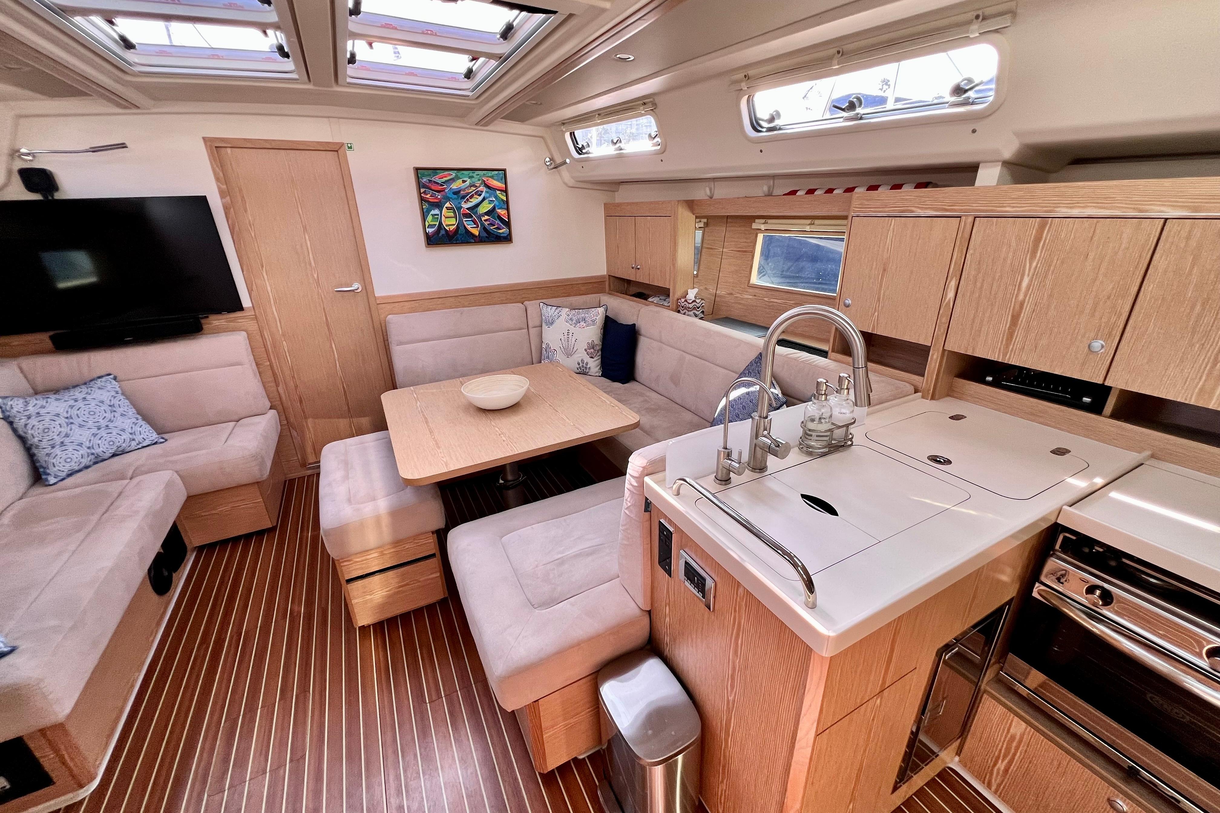 Luxurious interior of 2016 Hanse 455 yacht with modern kitchen and cozy seating area.