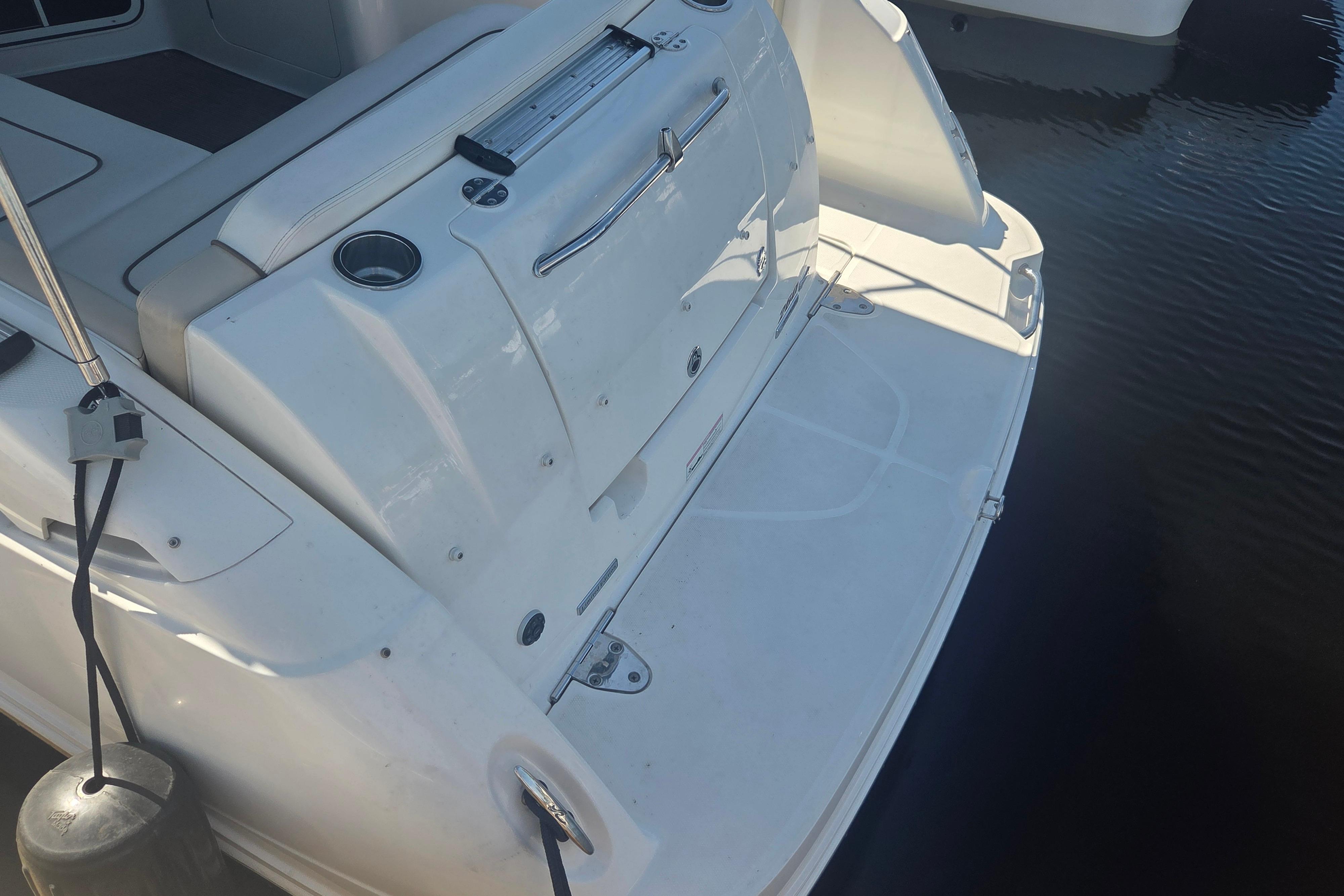 Rear view of a 2012 Sea Ray Sundancer 260 boat docked on water.