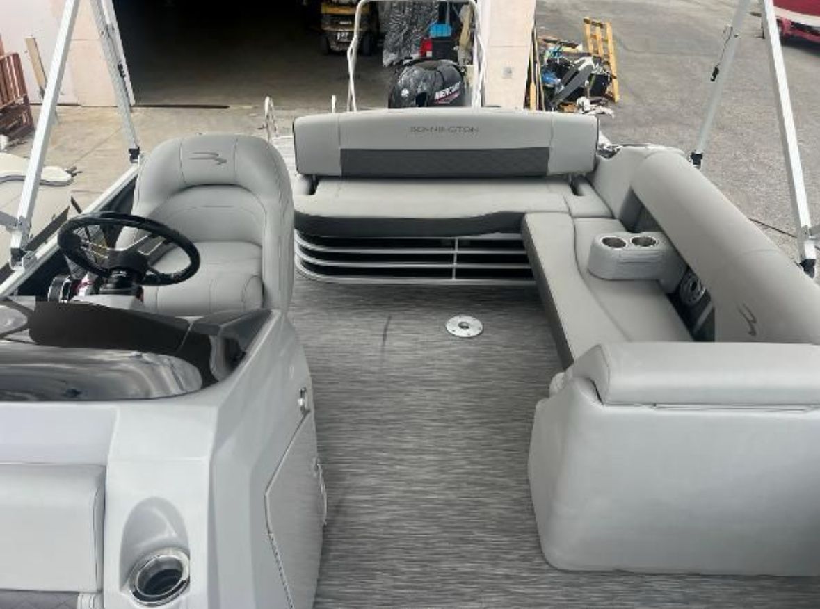 Interior of a Bennington L 23 Swingback pontoon boat with gray seating and steering wheel.