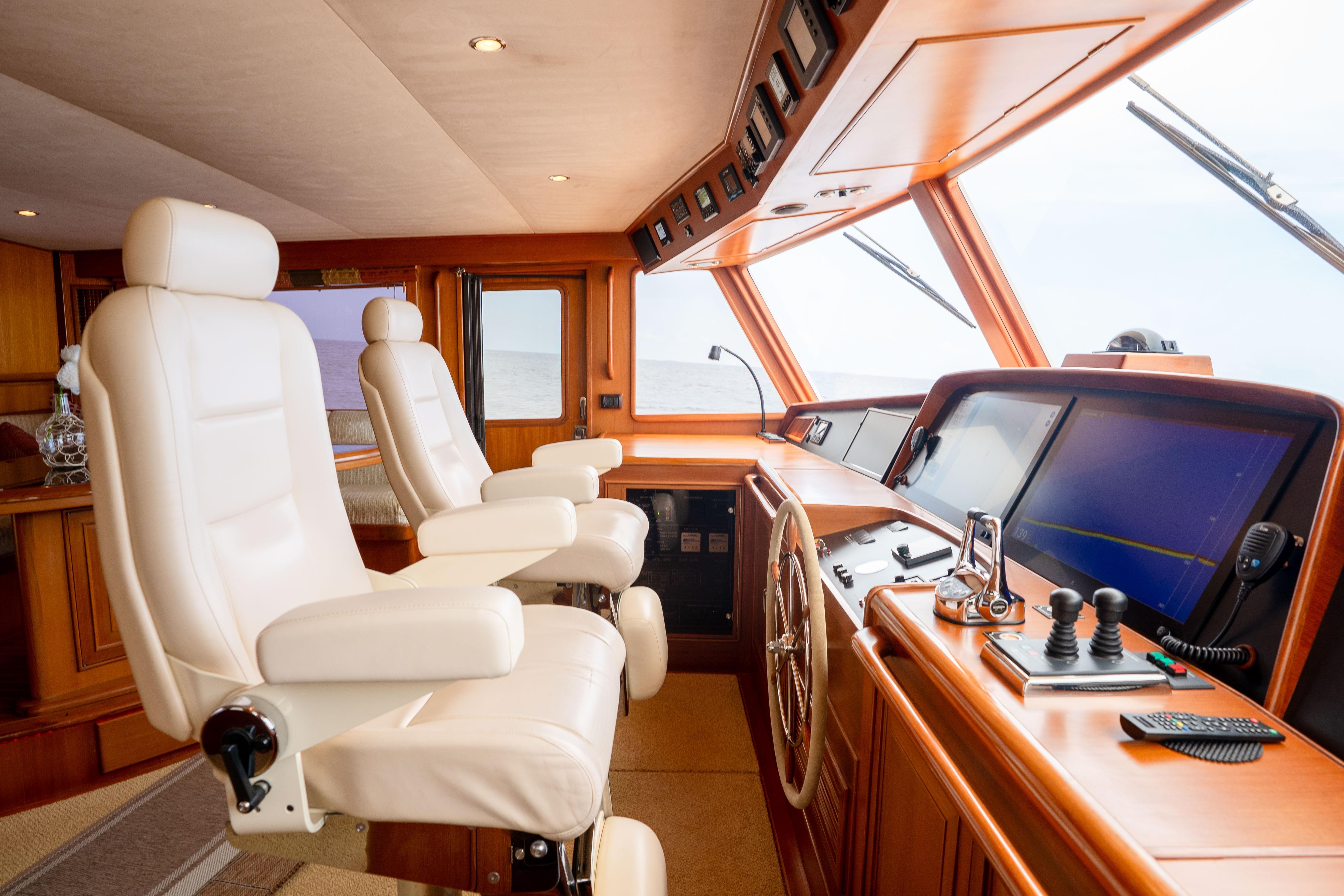 Luxurious 2006 Fleming 75 yacht helm with leather seats and advanced navigation controls.
