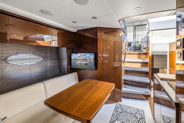 Interior of a 2013 Princess V57 yacht with wooden table and stairs.