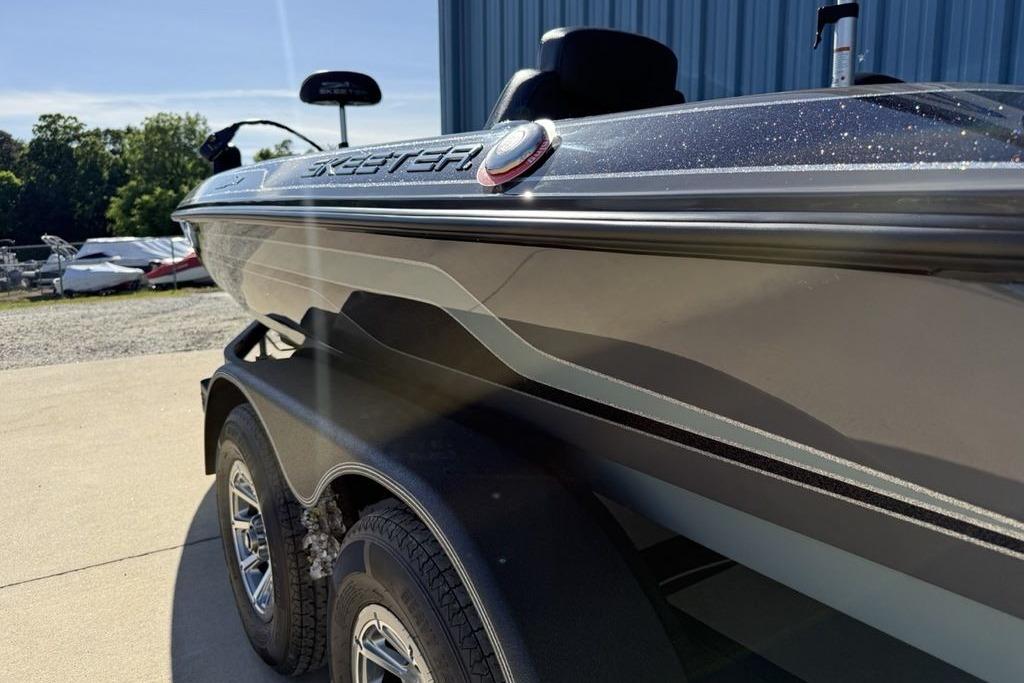 2026 Skeeter ZX150 boat on trailer, parked outdoors near a blue building.