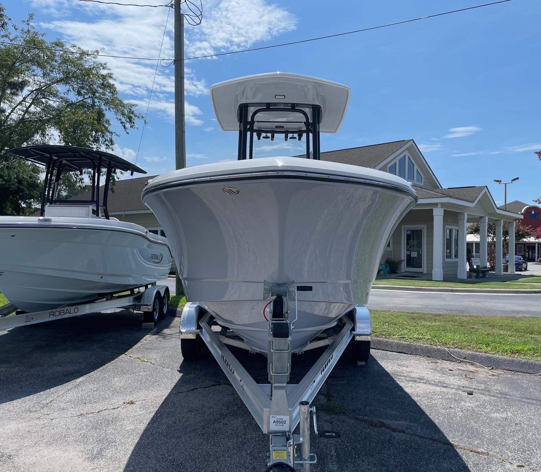 2025 Robalo R230 Center Console boat on trailer, displayed outdoors under clear sky.