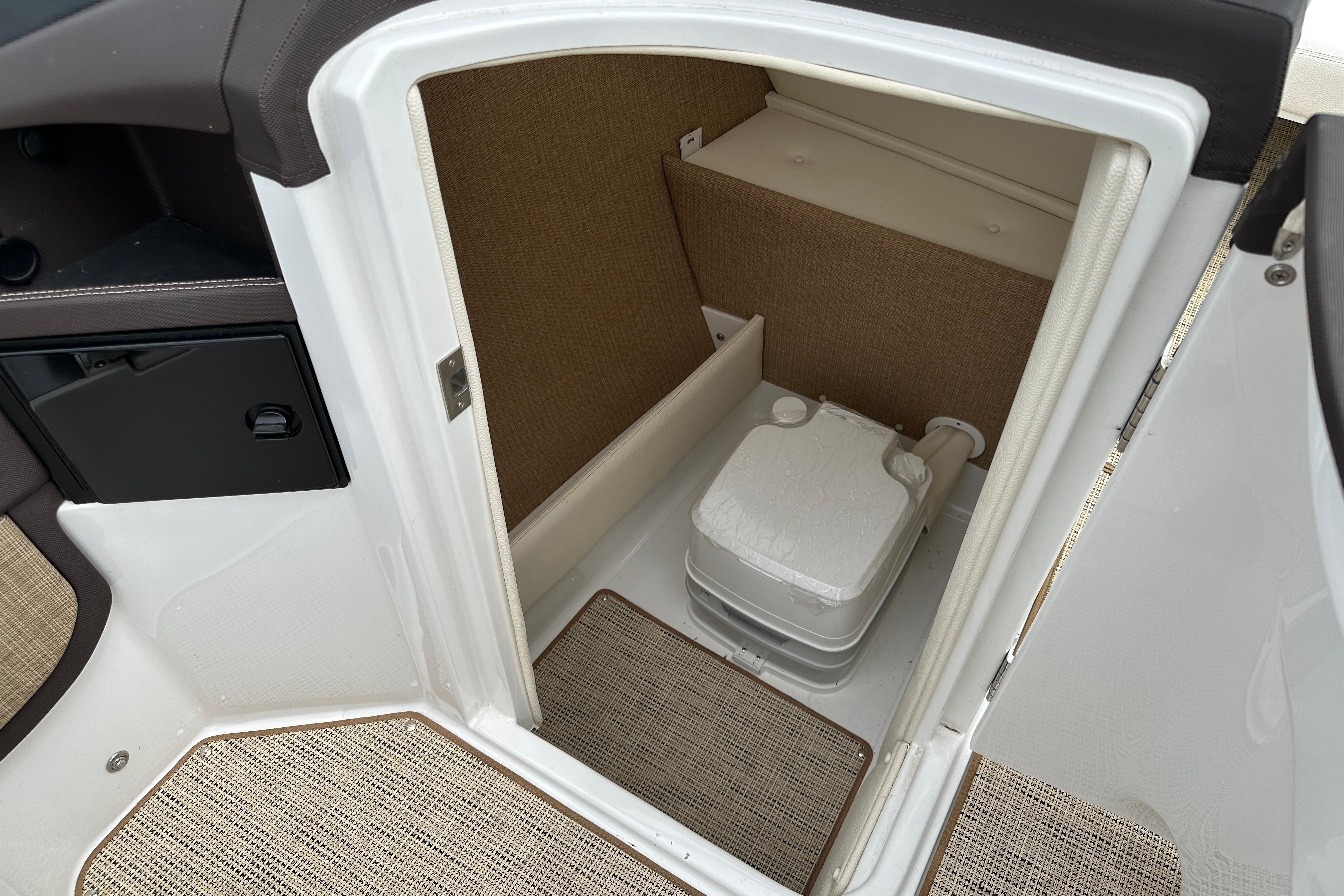 2019 Cobalt R5 boat interior with compact marine toilet and storage area.