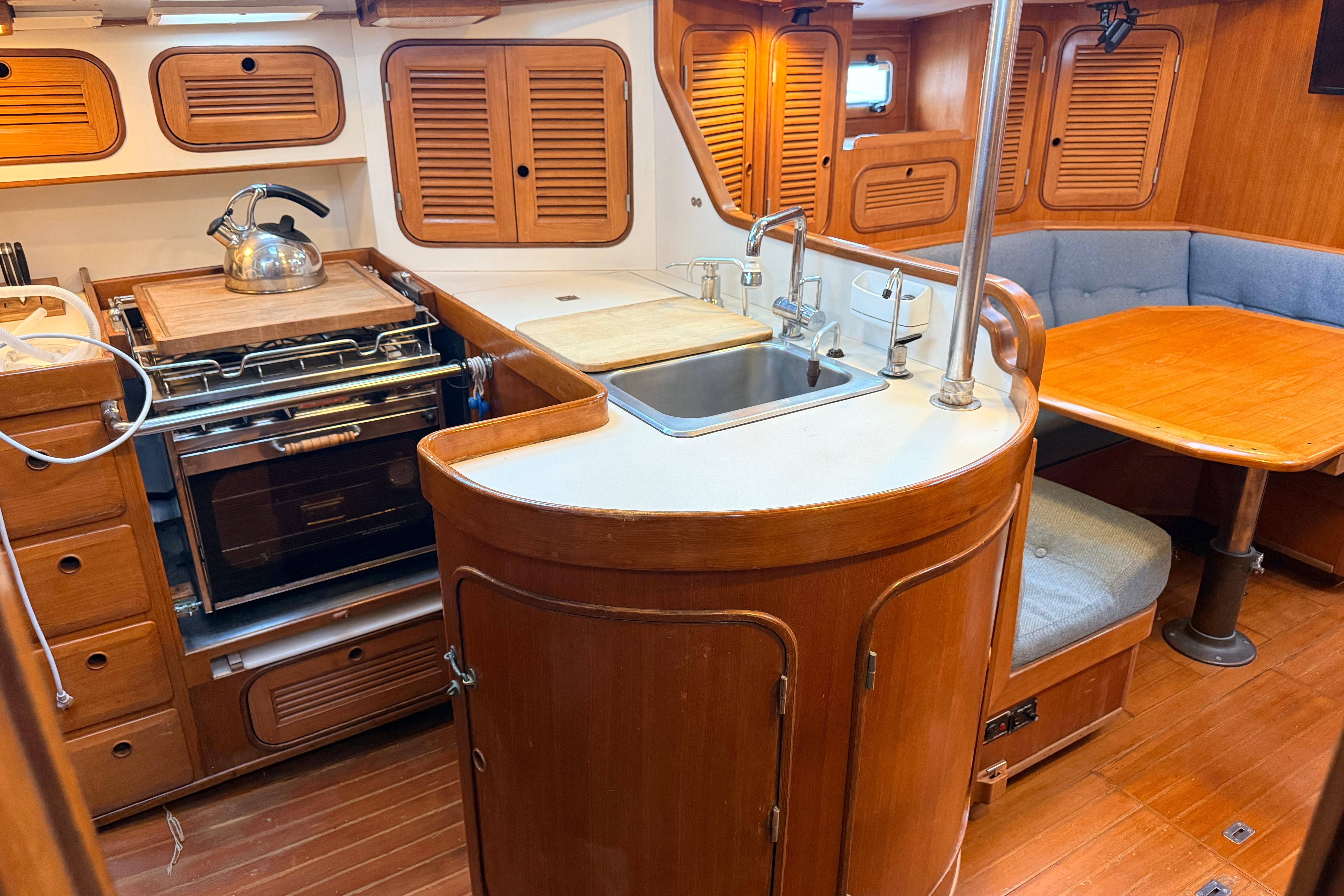 1987 Norseman 400 yacht interior with wooden cabinetry, kitchen, and dining area.