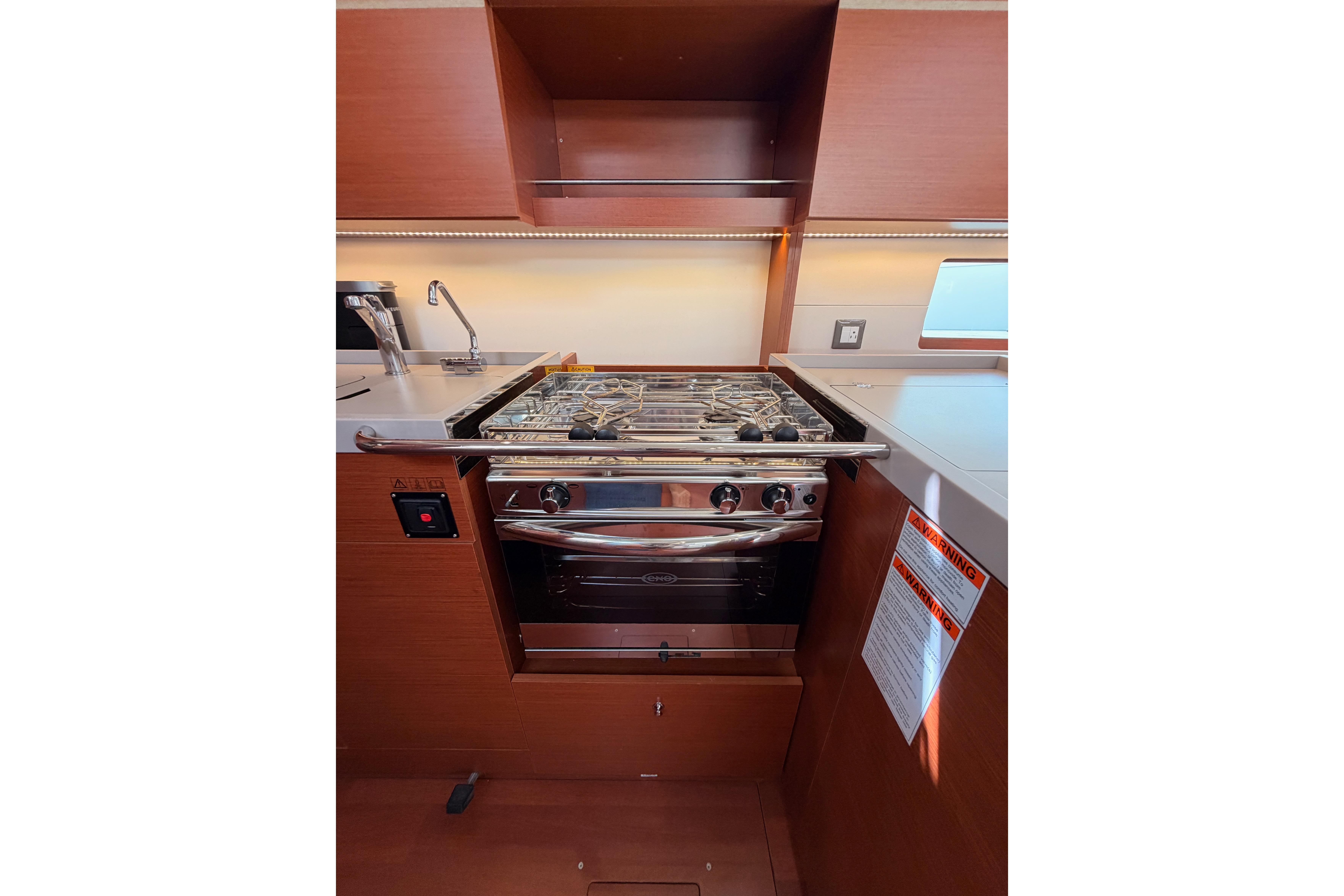 Modern kitchen area in a 2020 Beneteau Oceanis 46.1 yacht with stove and sink.