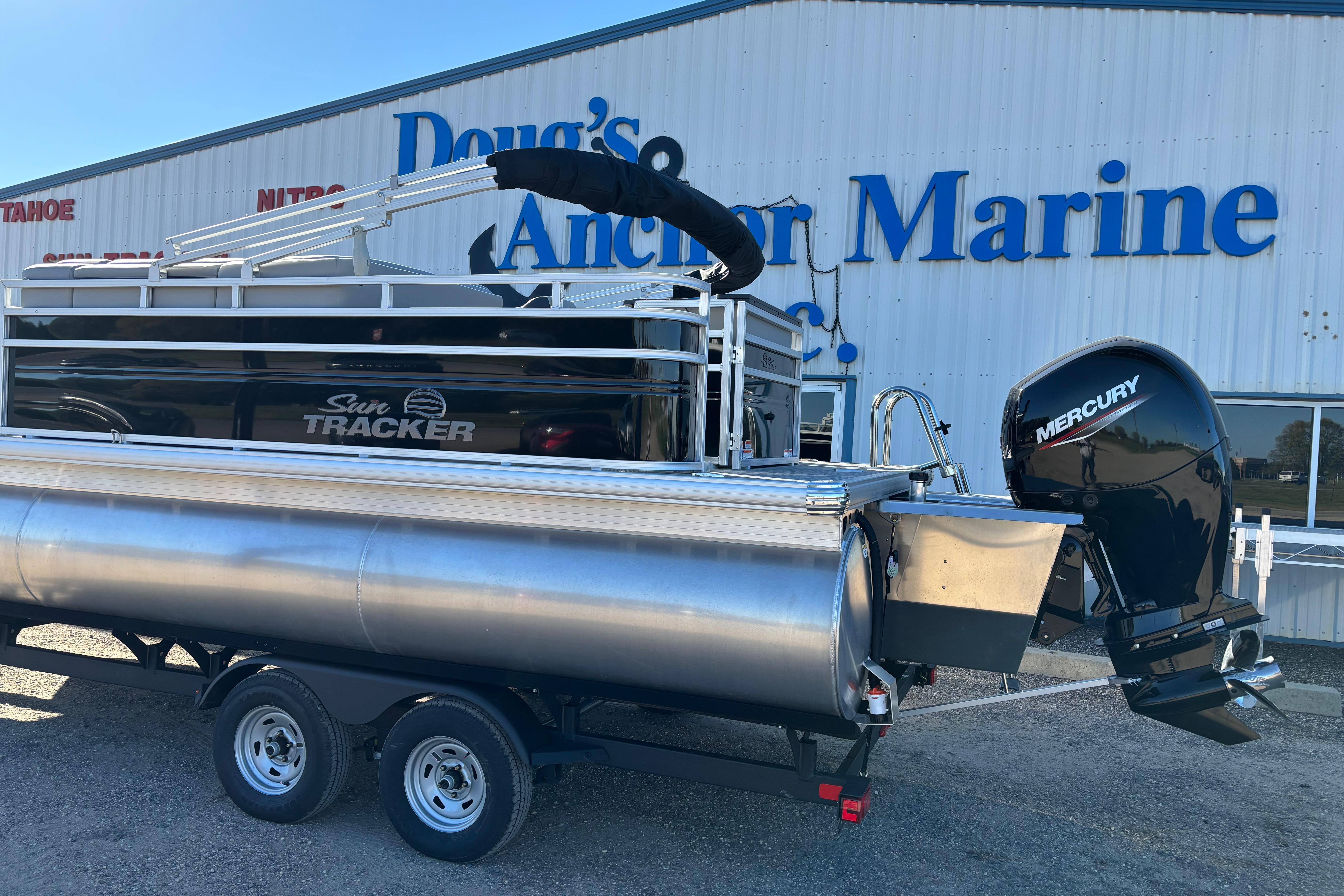 2026 Sun Tracker SportFish 22 XP3 pontoon boat with Mercury engine at marine dealership.