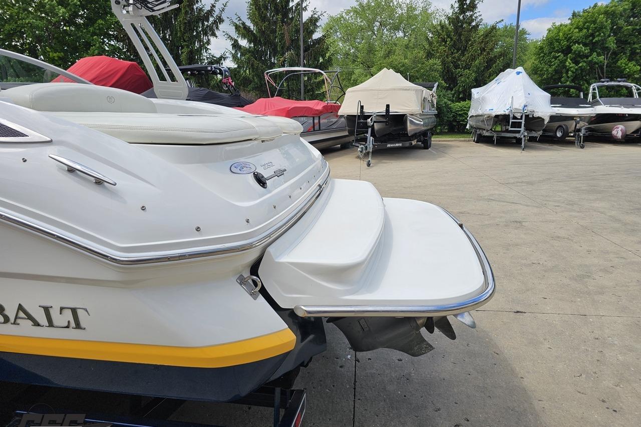 2010 Cobalt 232 WSS boat with swim platform, parked among covered boats.