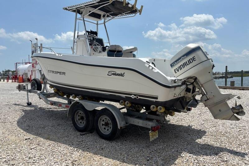 2002 Seaswirl Striper 2101 Center Console boat on trailer, featuring Evinrude outboard motor.