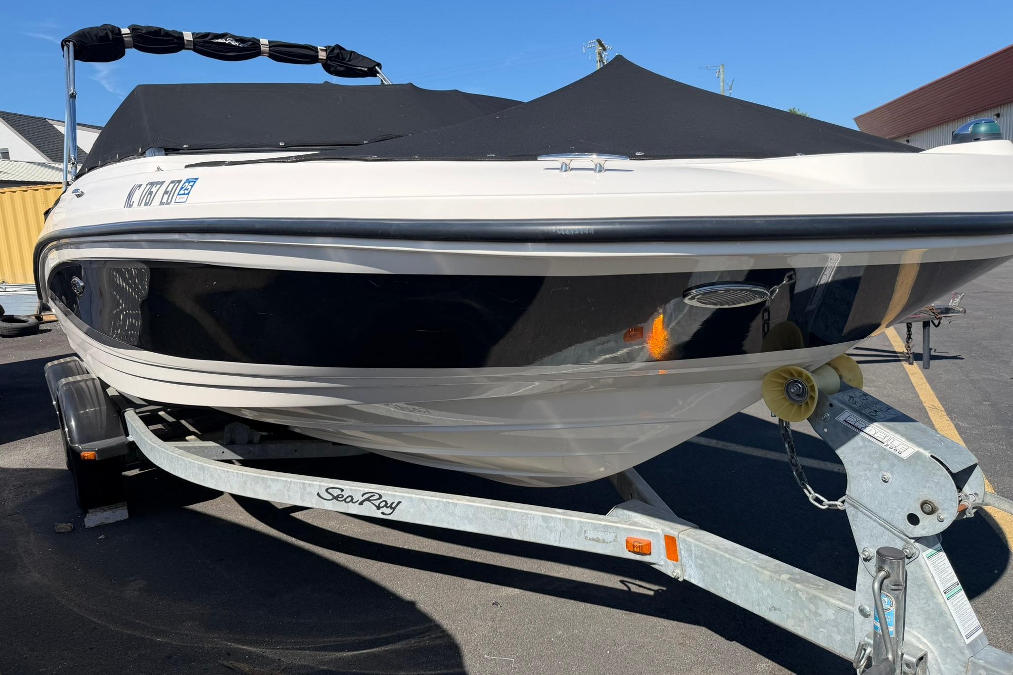 2016 Sea Ray SPX 210 boat on trailer, covered and parked outdoors.