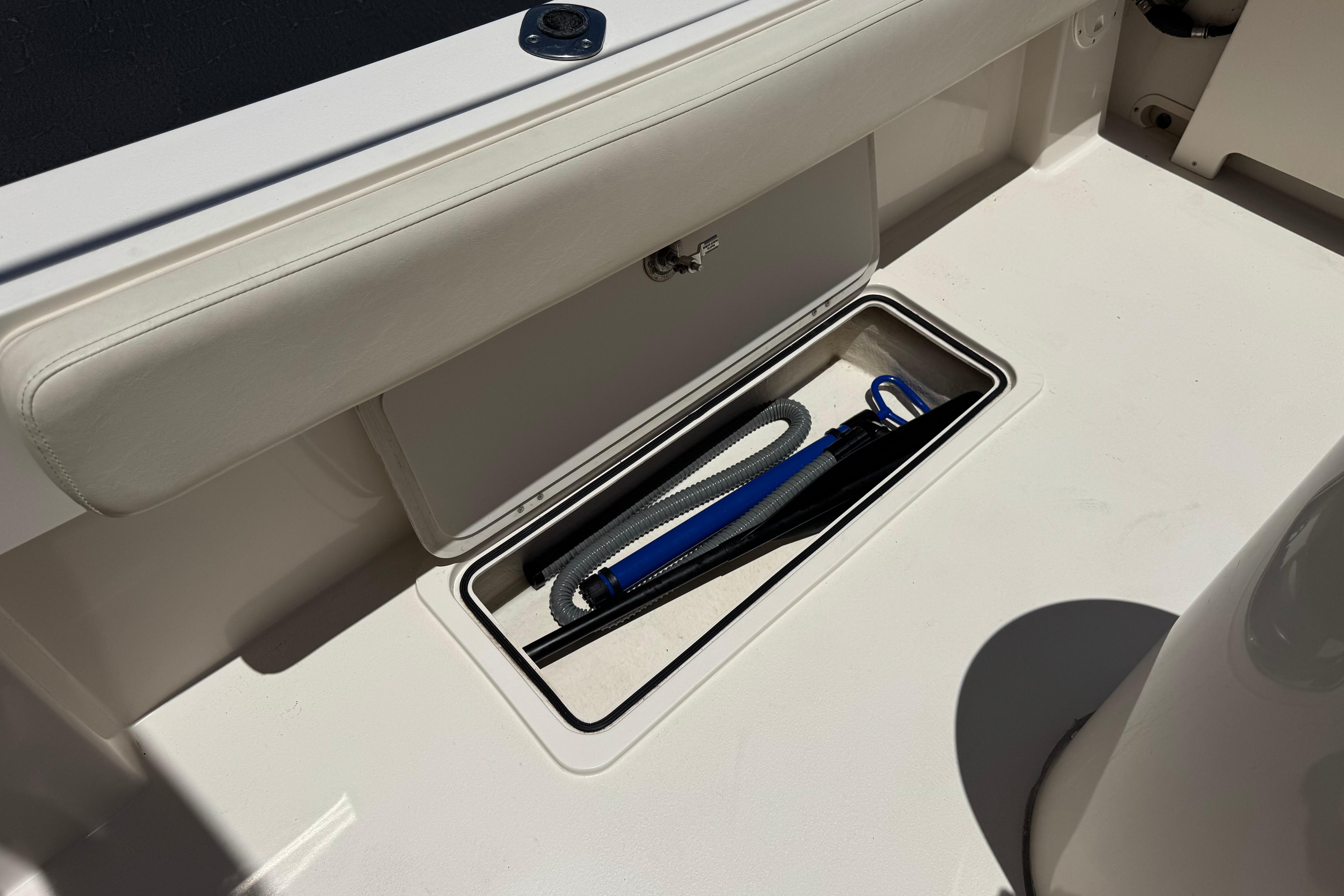 Storage compartment on a 2017 Defiance Admiral 220 EX boat, containing ropes and equipment.