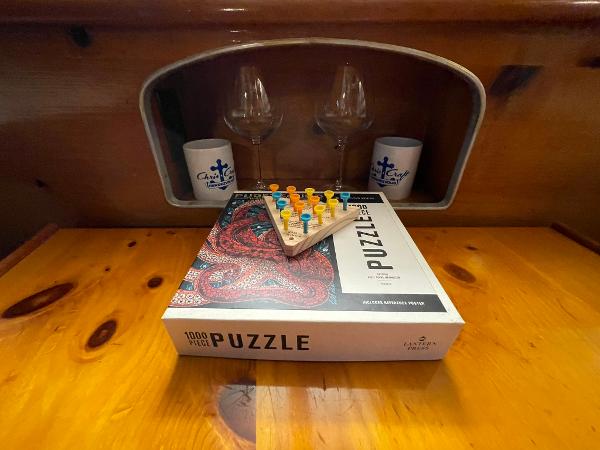 1951 Chris-Craft Catalina interior with puzzle box and peg game on wooden table.