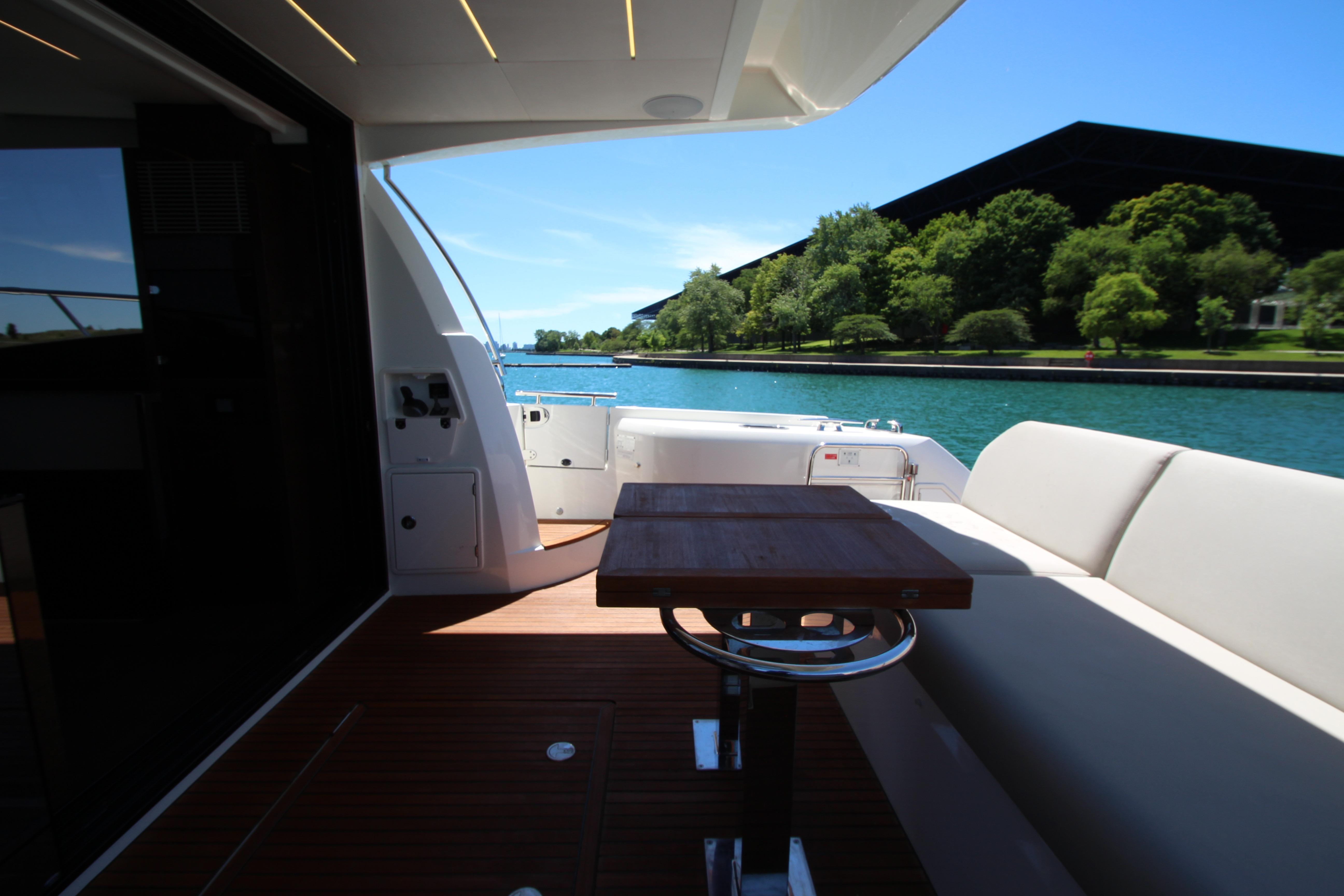 Luxury 2022 Prestige 520 yacht deck with seating and scenic waterfront view.