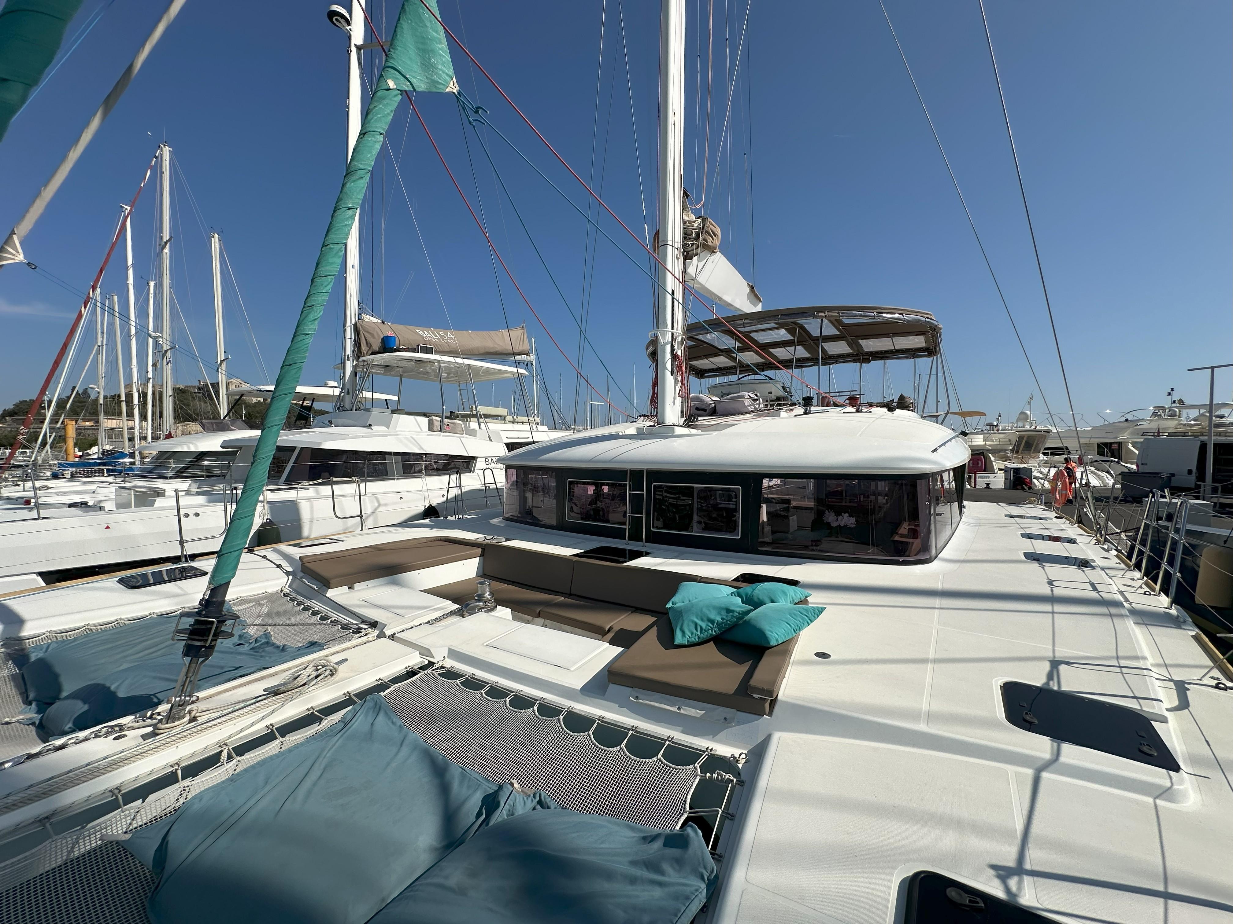 2011 Lagoon 560 catamaran docked at marina, featuring spacious deck and seating area.