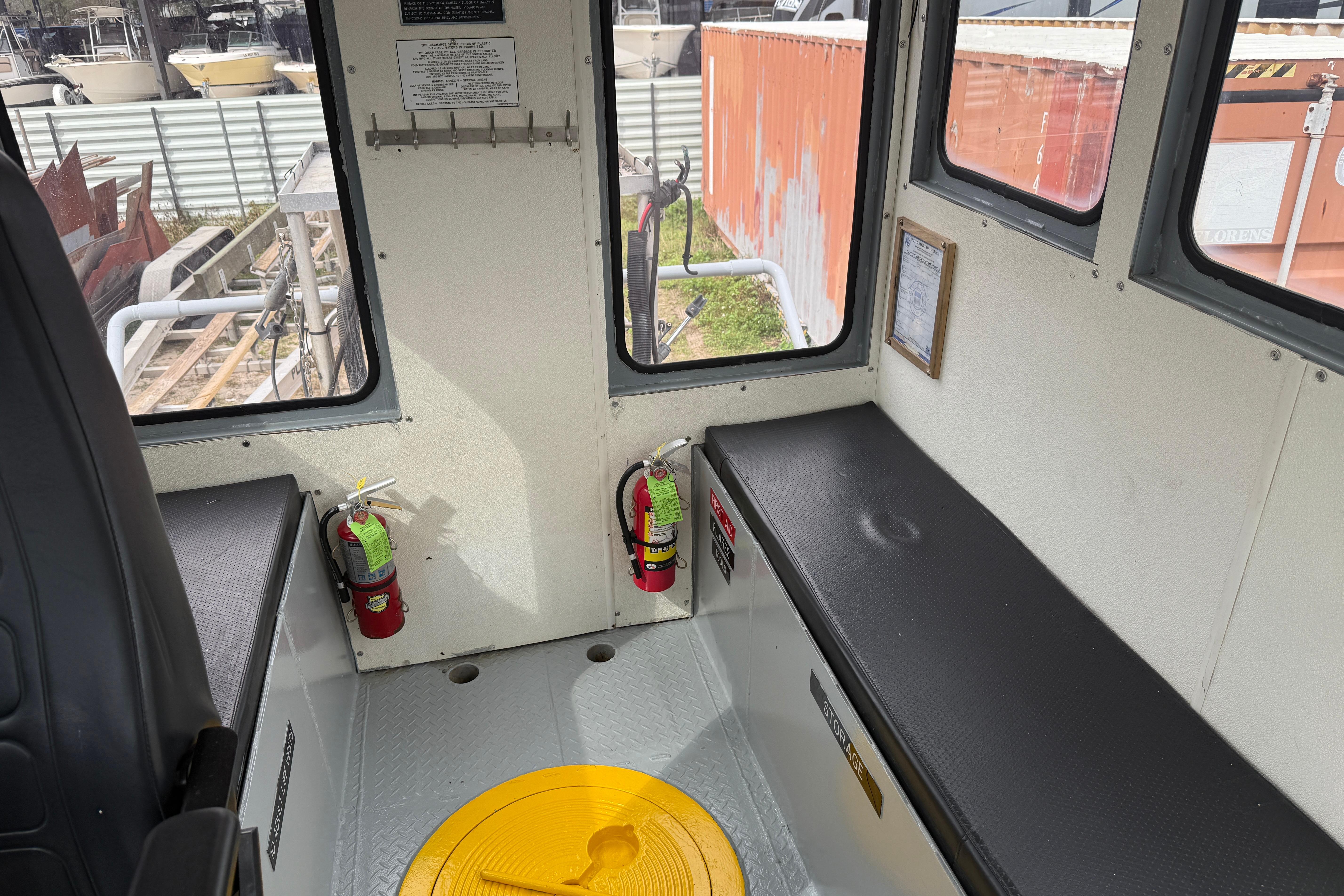 Interior of 2010 Custom Aluminum Work Boat 34x10 with fire extinguishers and seating.