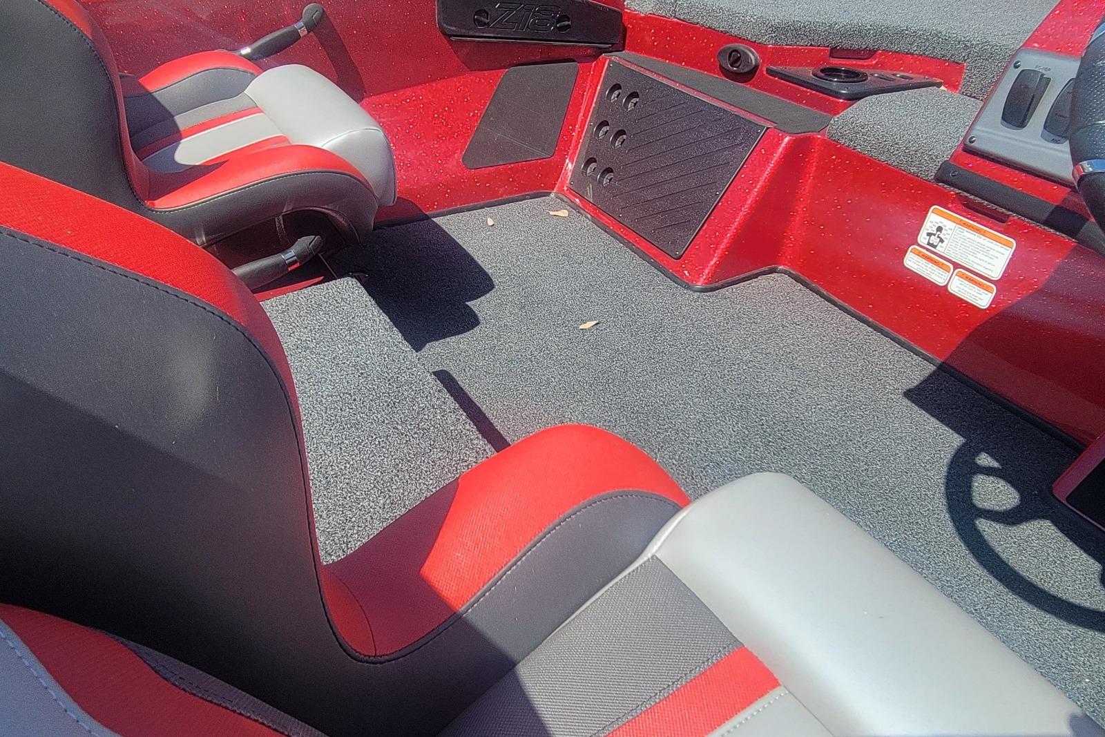 Interior of 2026 Nitro Z18 boat with red and gray seating and carpeted floor.
