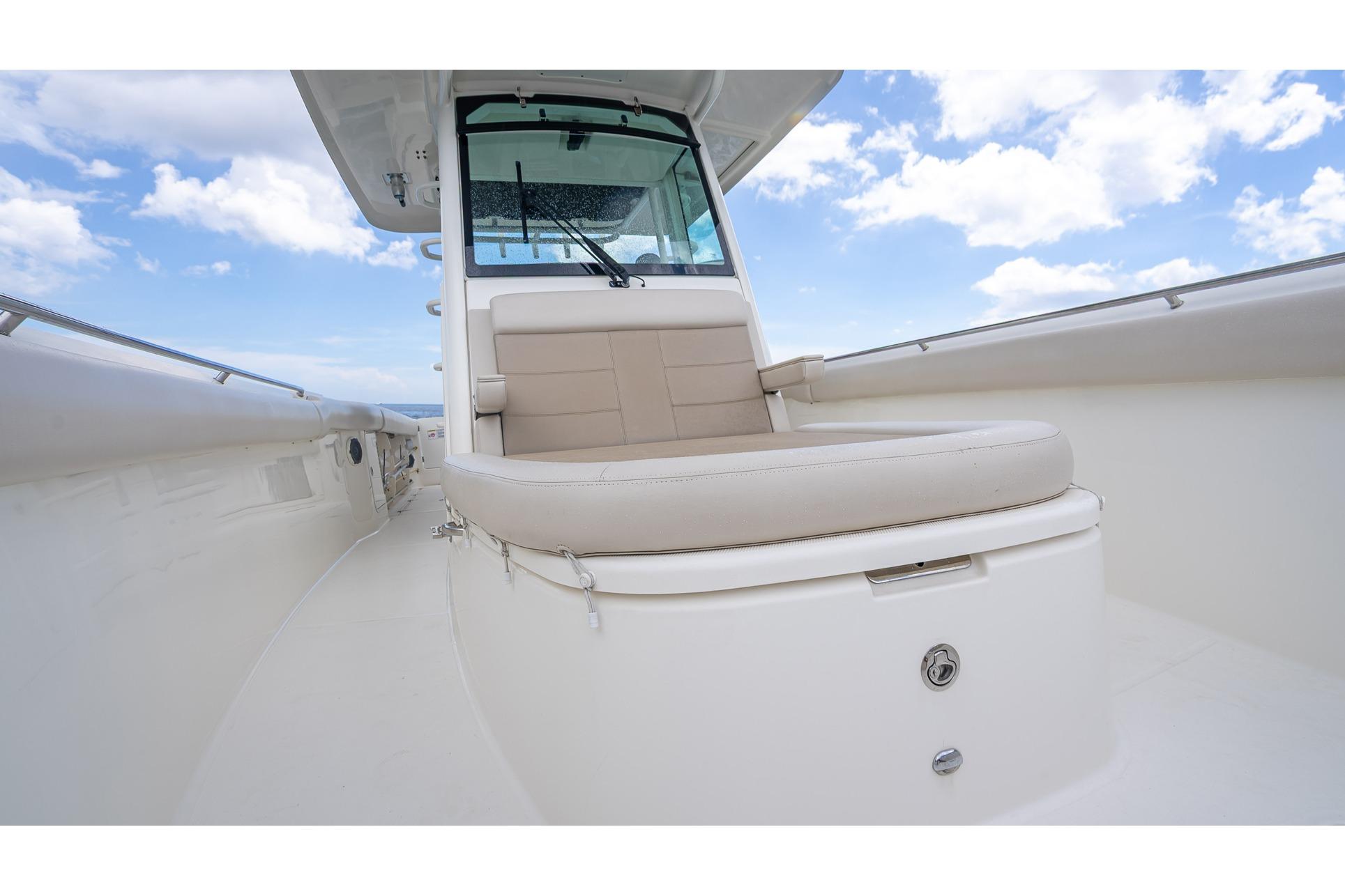 2017 Boston Whaler 330 Outrage boat interior with cushioned seating under a blue sky.