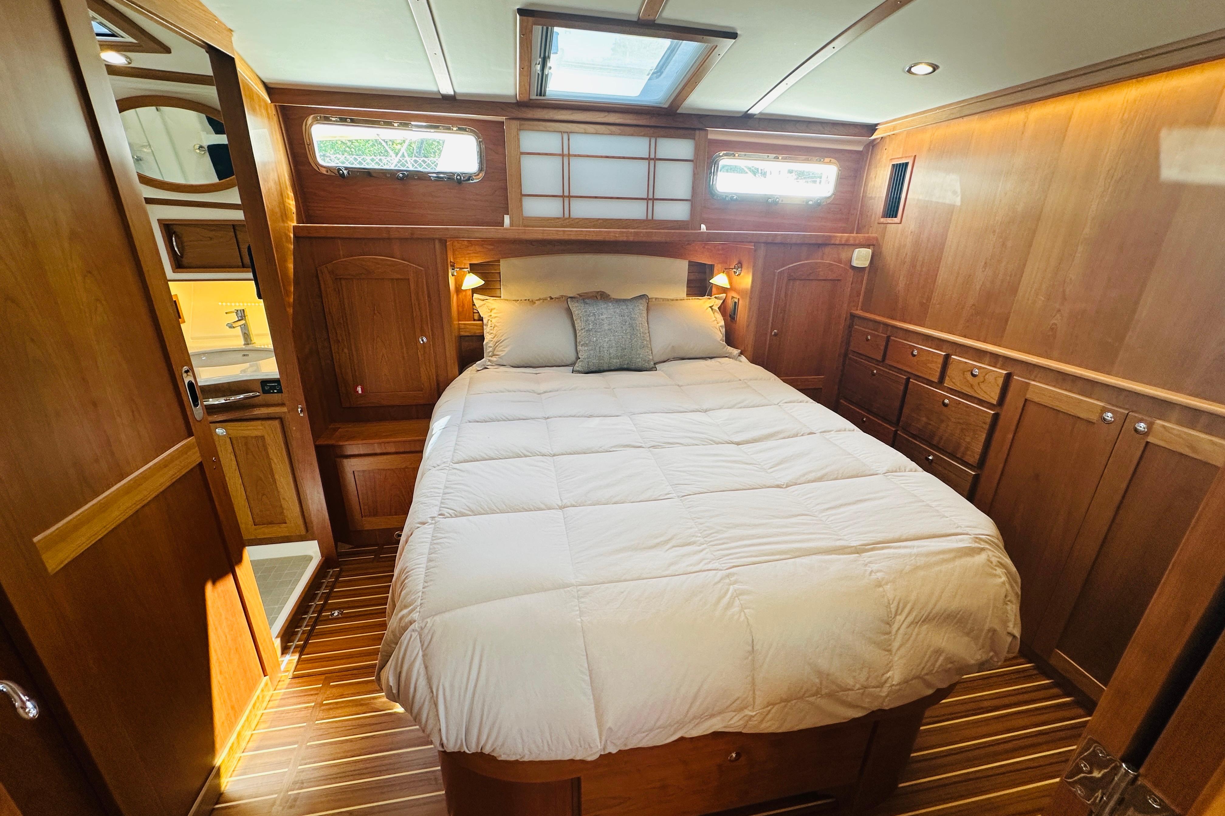 Luxurious bedroom interior of 2025 Sabre 48 Salon Express yacht with wood paneling.