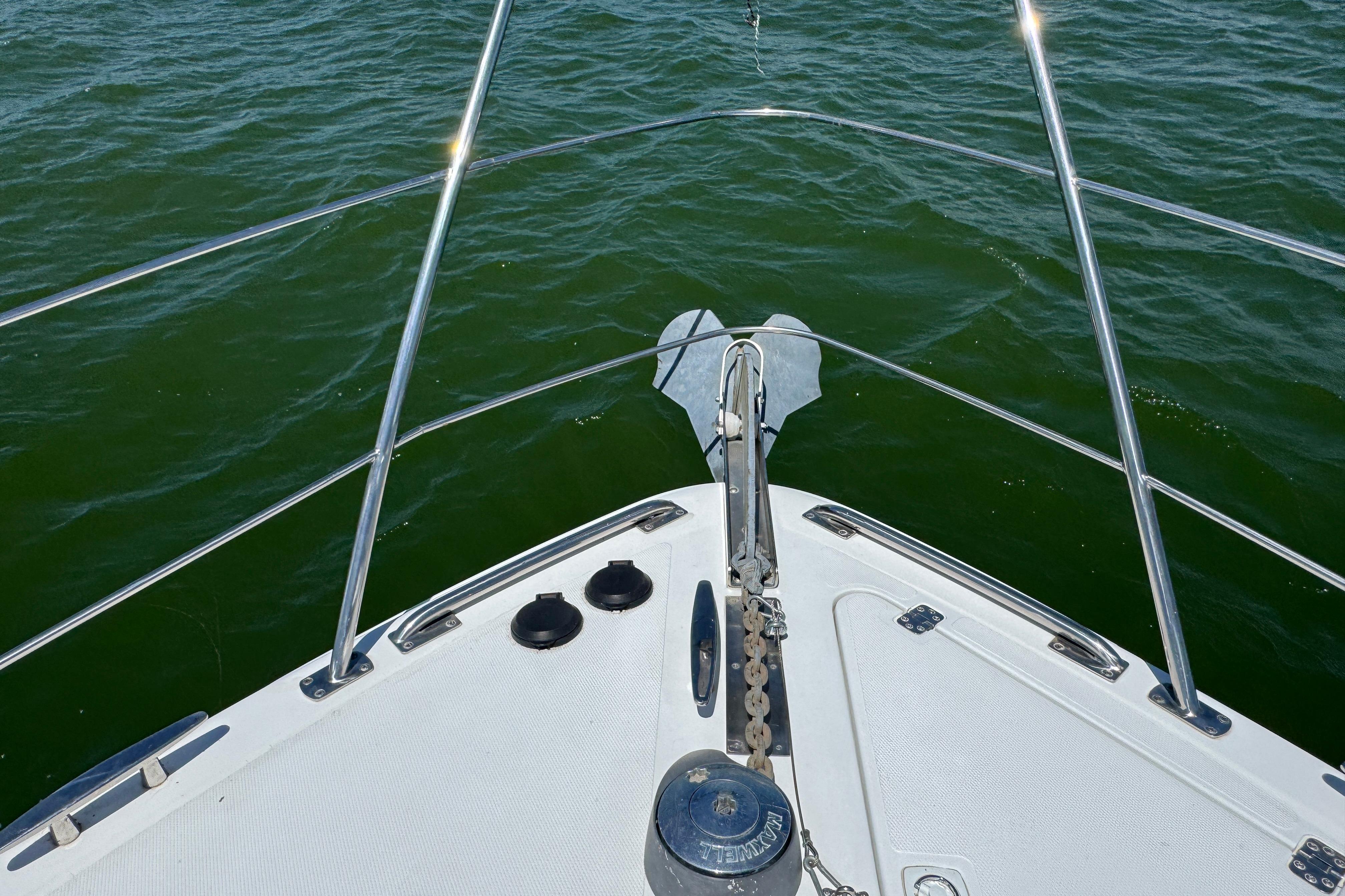 Bow view of 2002 Carver 396 Motor Yacht on green water.