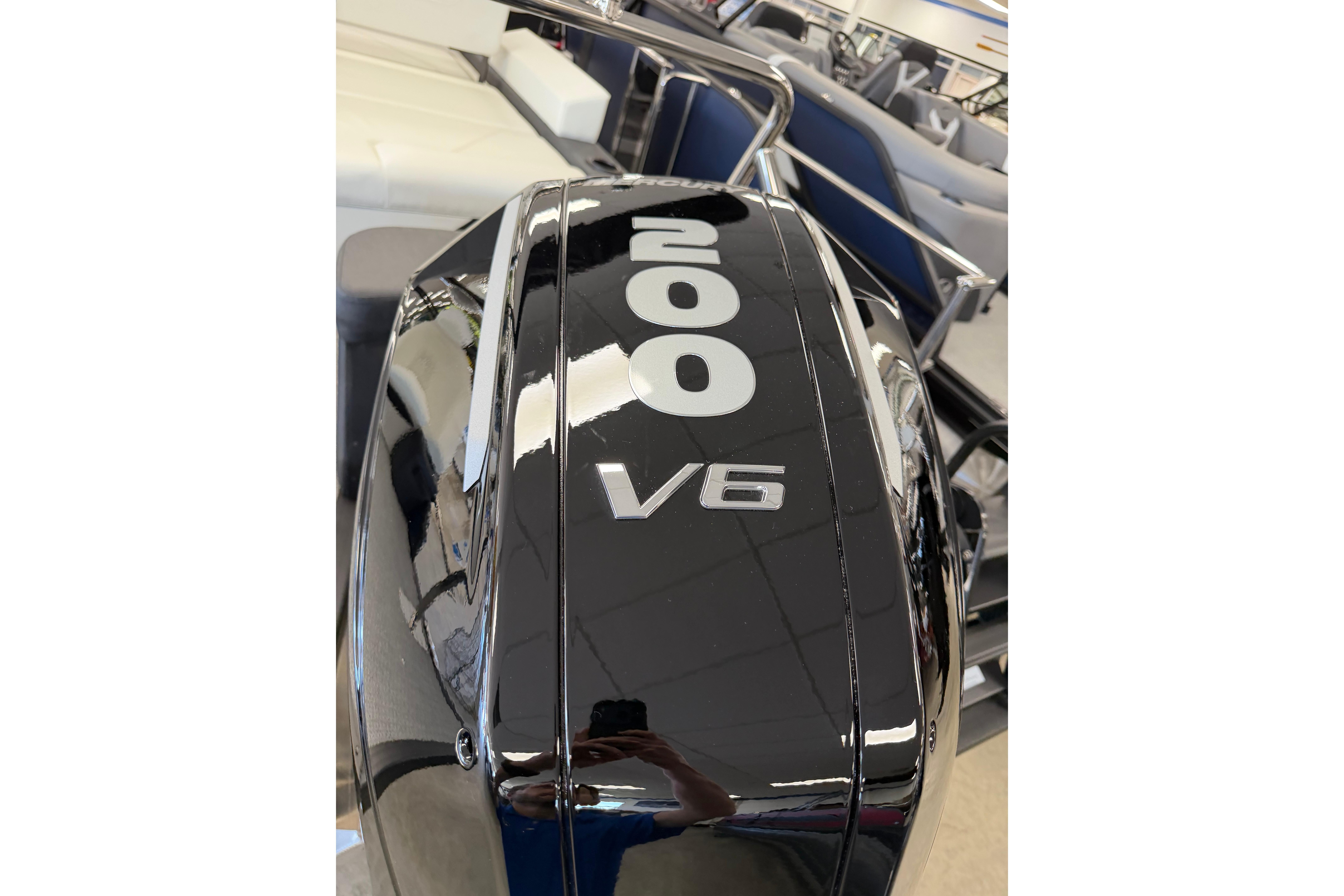 Black Evotti 721CS 2026 outboard motor, featuring "200 V6" label, in showroom setting.