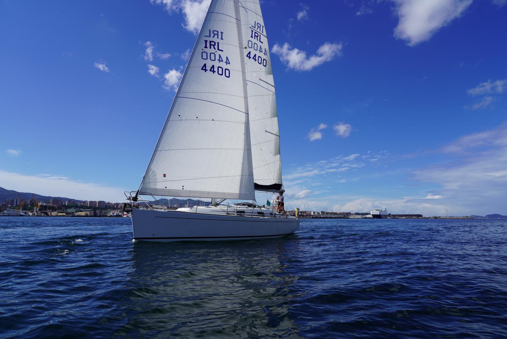 Sailing yacht Grand Soleil 40, 2002 model, gliding on calm waters under a clear blue sky.