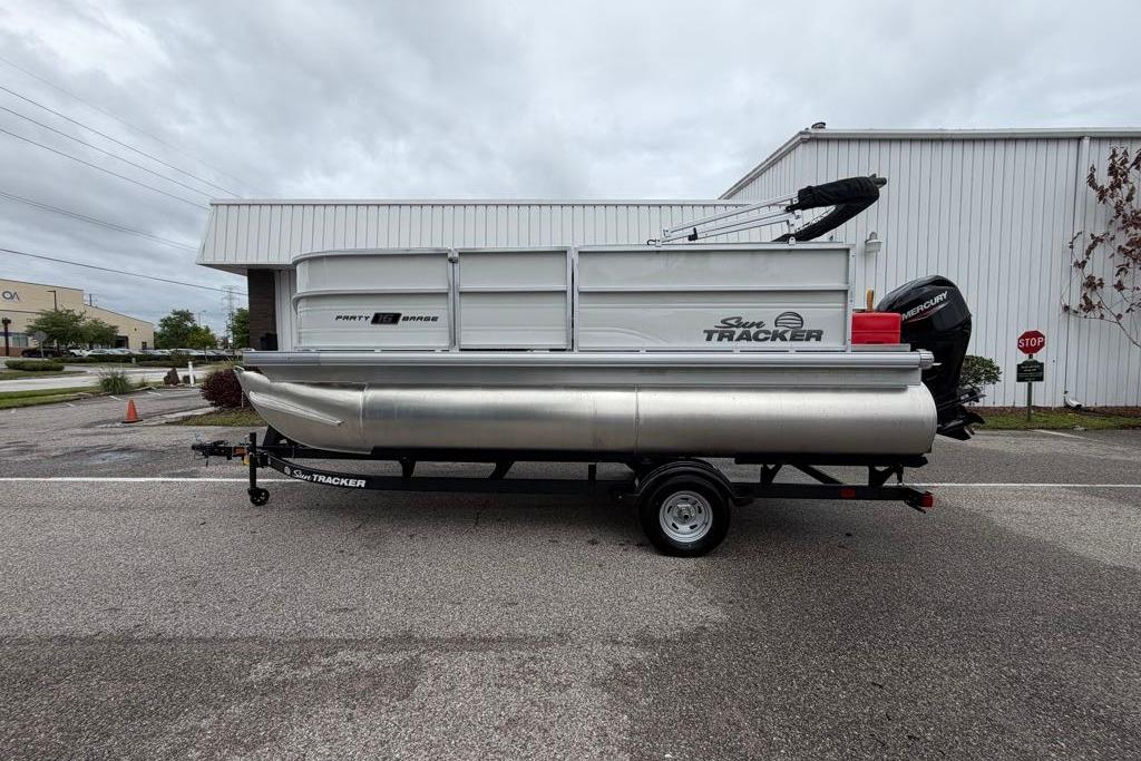 2026 Sun Tracker Party Barge 16 DLX pontoon boat on trailer, parked outdoors.