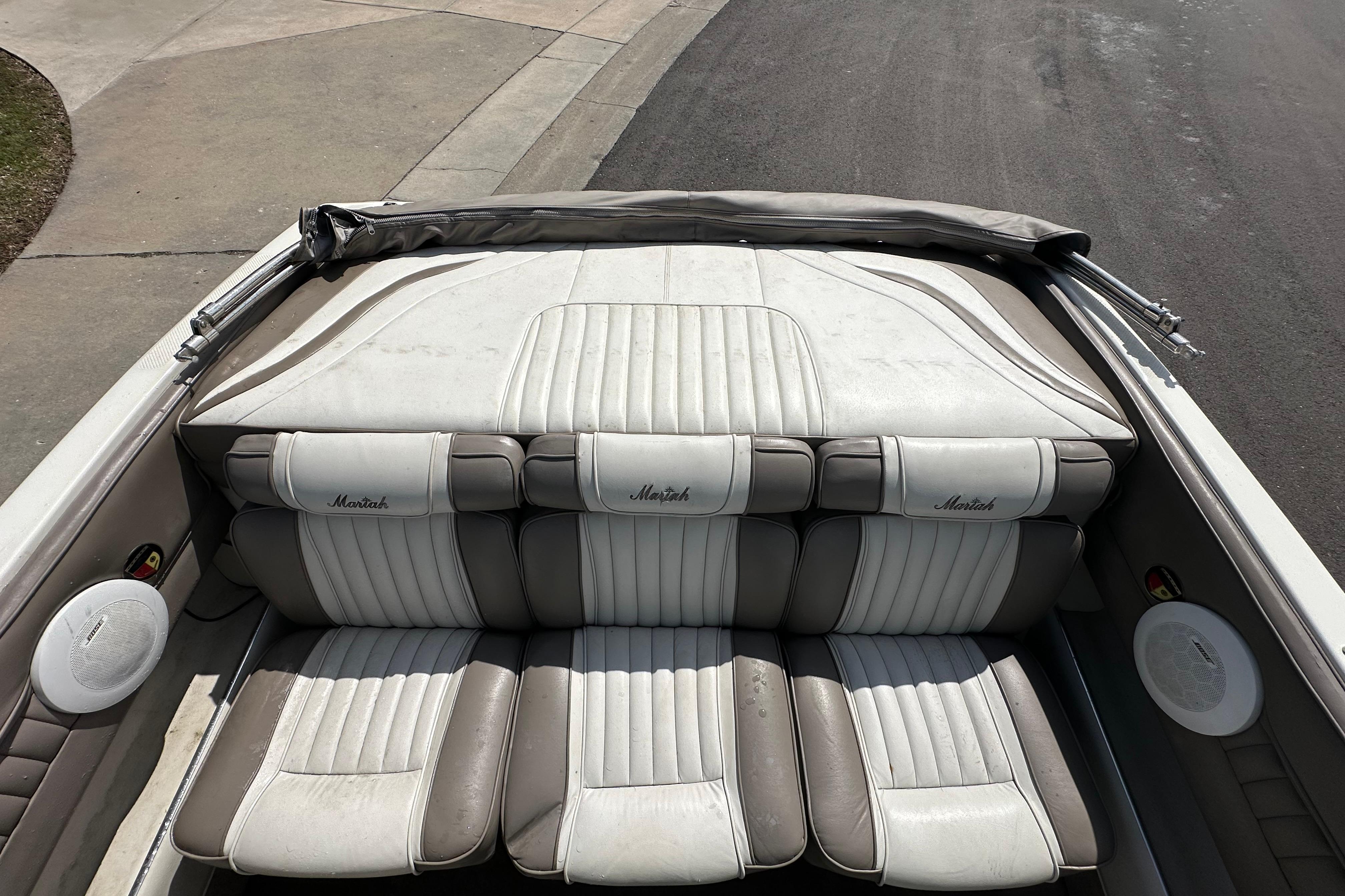 1995 Mariah 180 Shabah boat interior with white and gray seating, parked on pavement.
