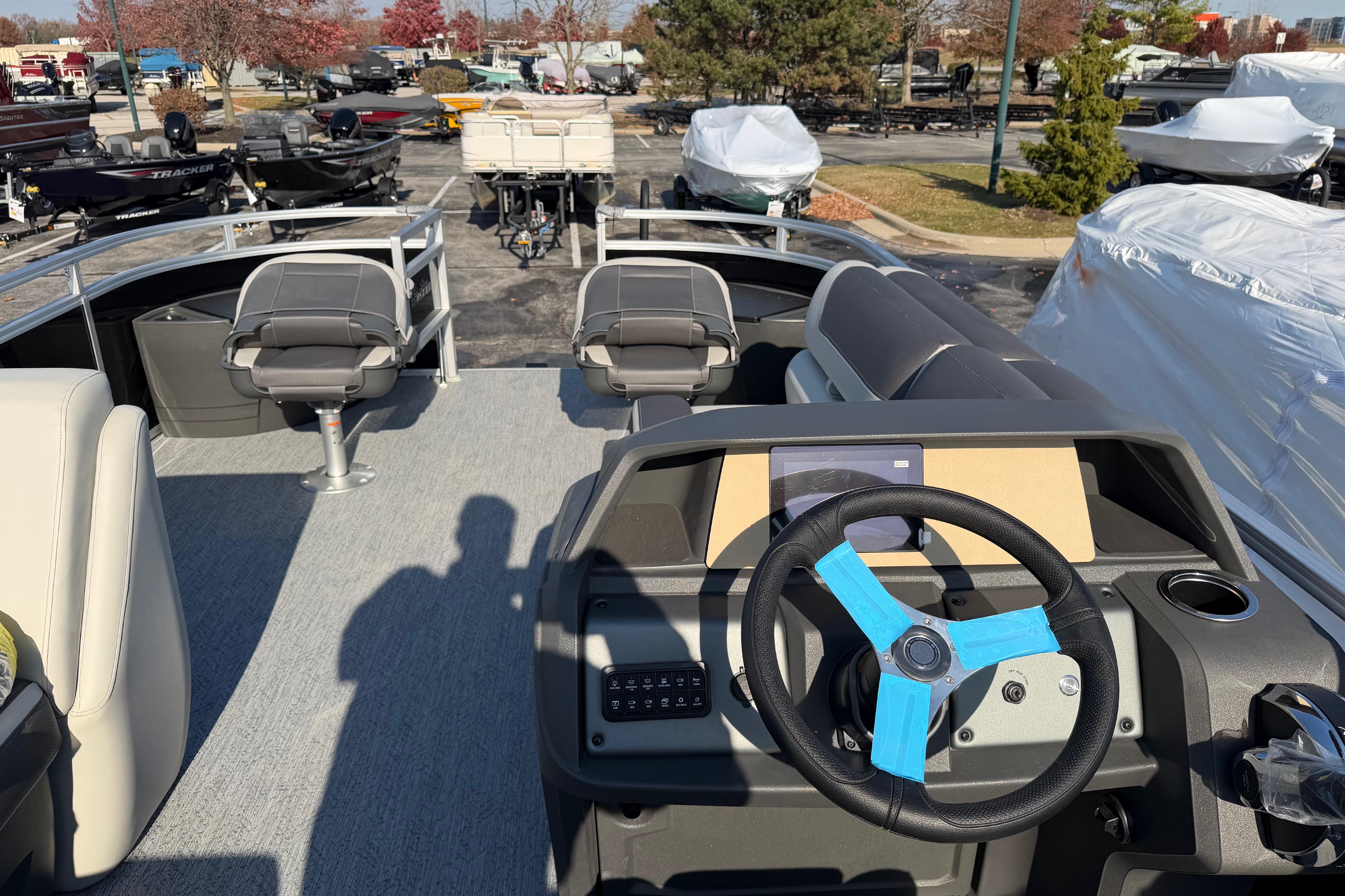 2026 Sun Tracker Fishin' Barge 20 DLX interior with steering wheel and seating.