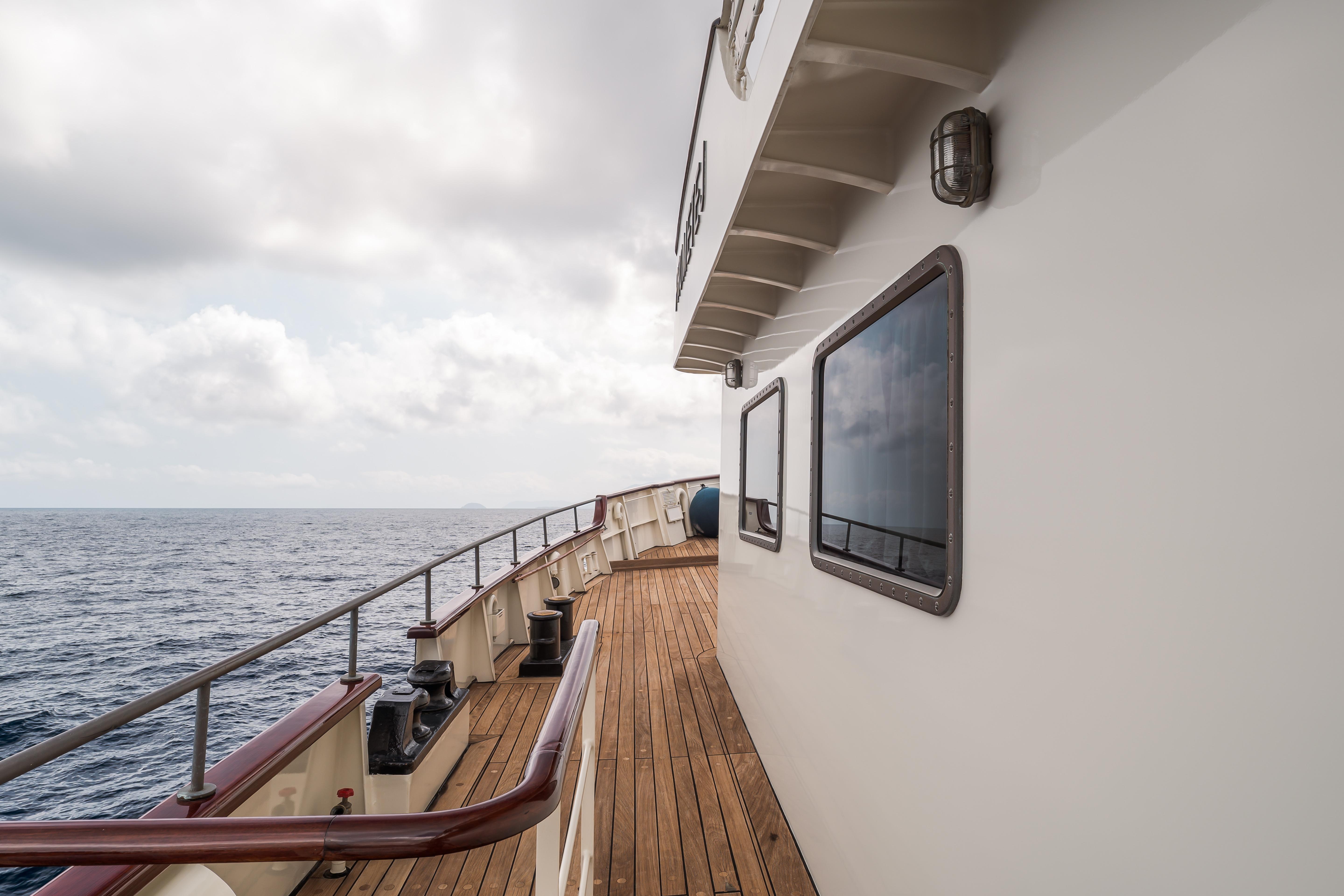 1956 custom converted tugboat deck with ocean view and cloudy sky.