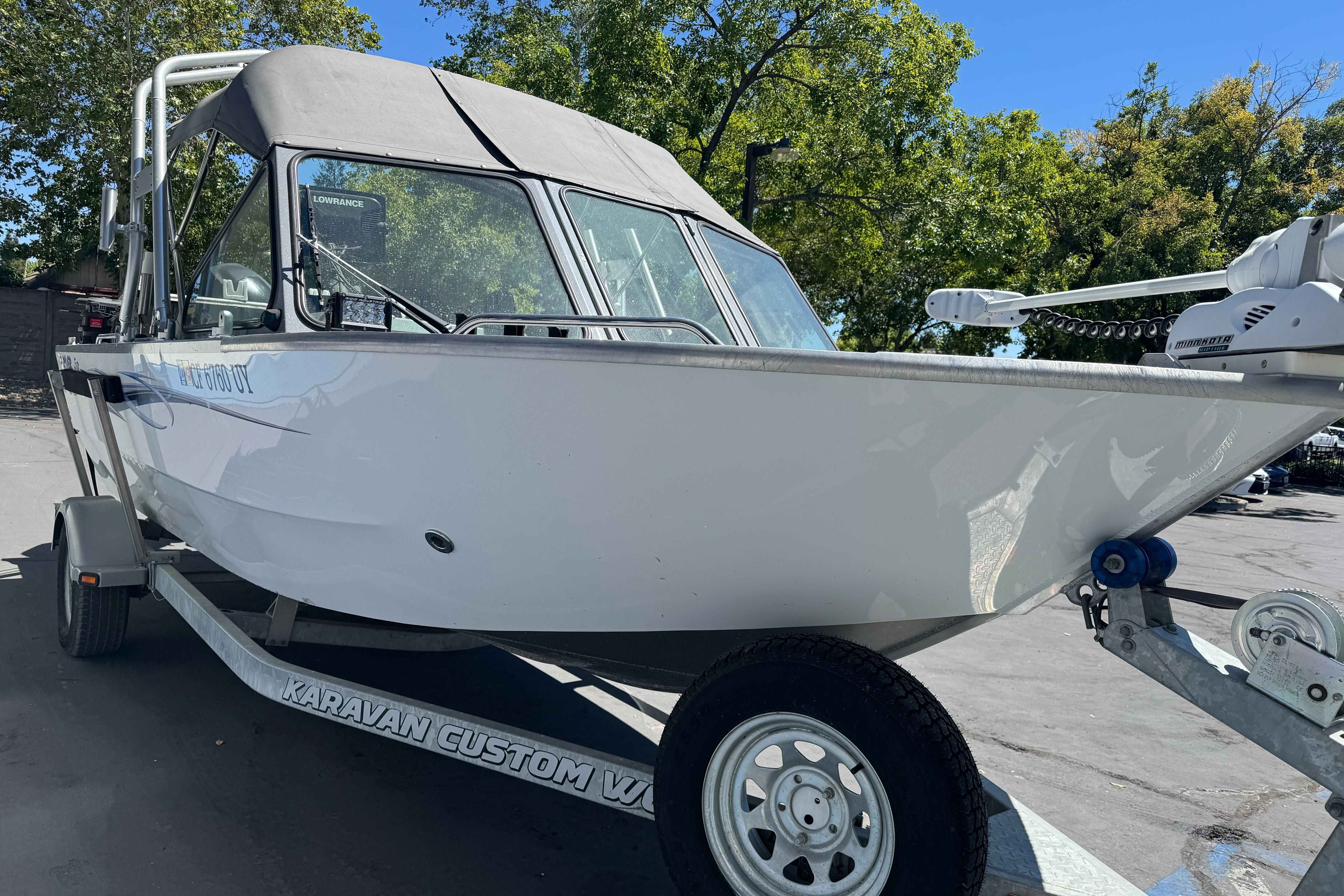 2014 River Hawk 19 GB boat on trailer, parked outdoors under clear sky.