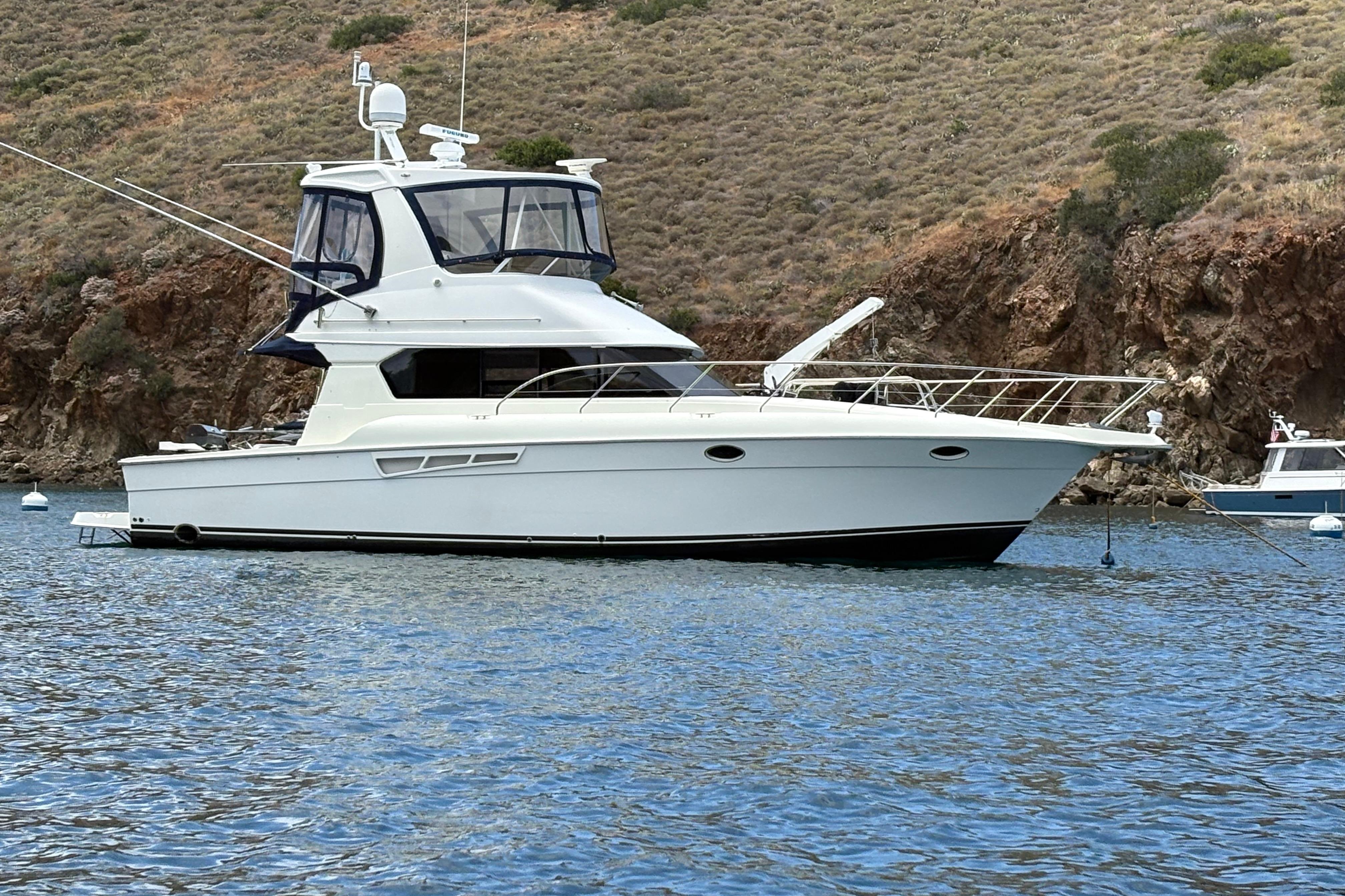 2000 Silverton 42 Convertible yacht anchored in scenic coastal waters.