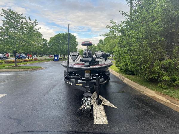 2025 Nitro Z20 XL Pro boat parked on wet road, surrounded by greenery.